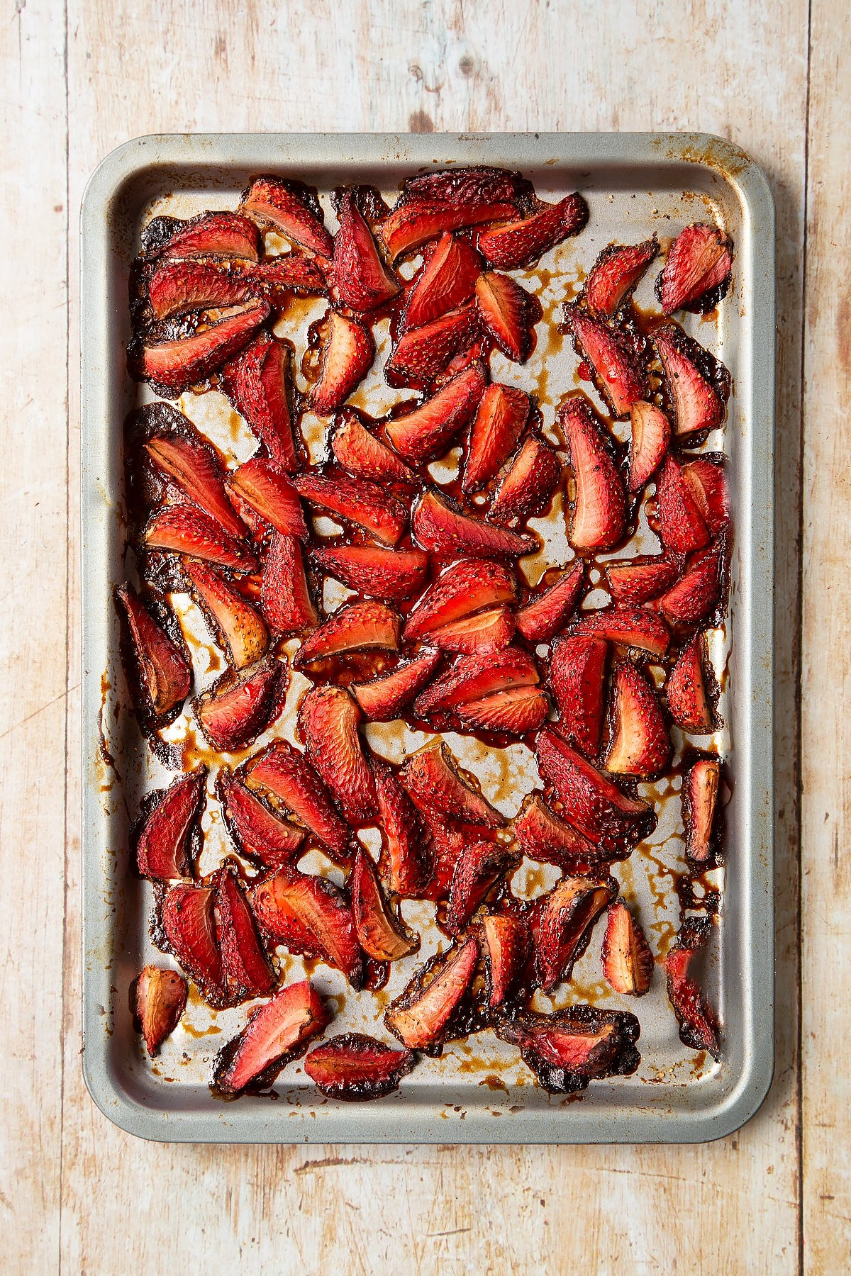 Roasted balsamic strawberries on a non-stick tray.