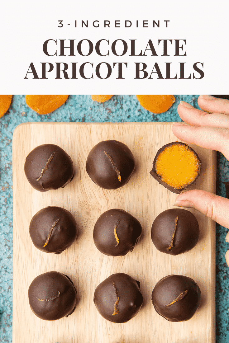 12 chocolate apricot balls arranged on a wooden board. A hand reached for one that has been cut in half, revealing the bright orange apricot filling. Caption reads: 3-ingredient chocolate apricot balls.