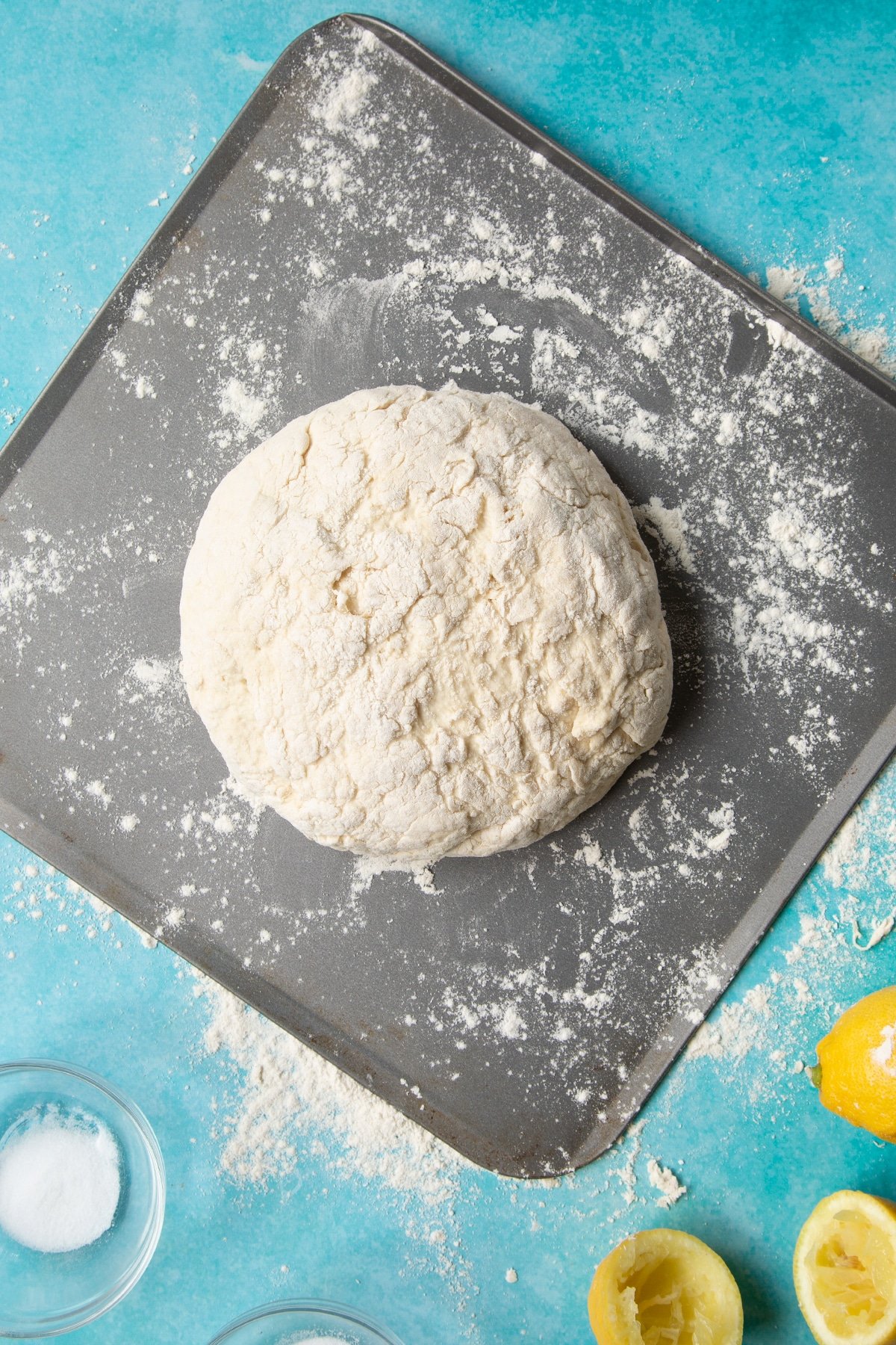 Vegan soda bread dough shaped into a round on a floured baking sheet.