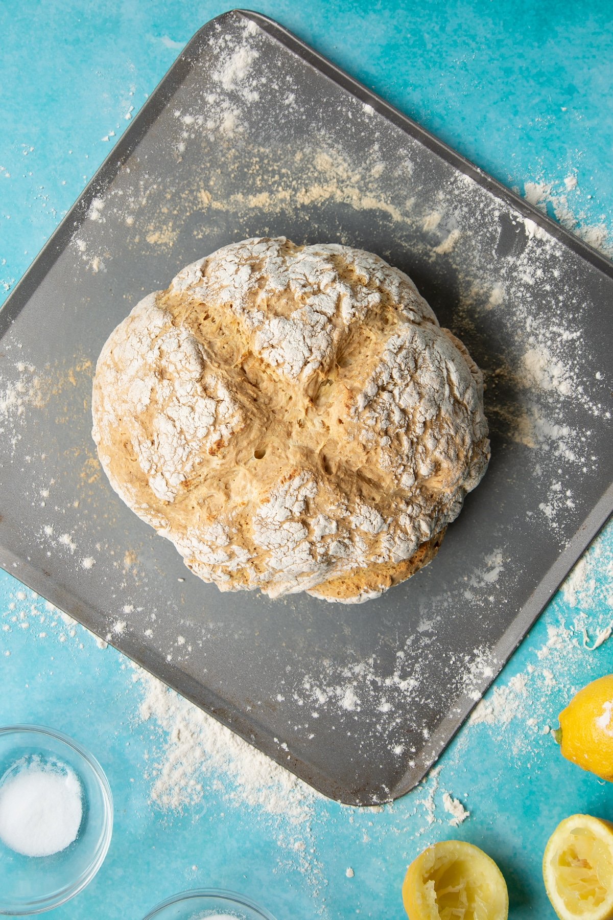 Freshly baked vegan soda bread on a floured baking sheet.