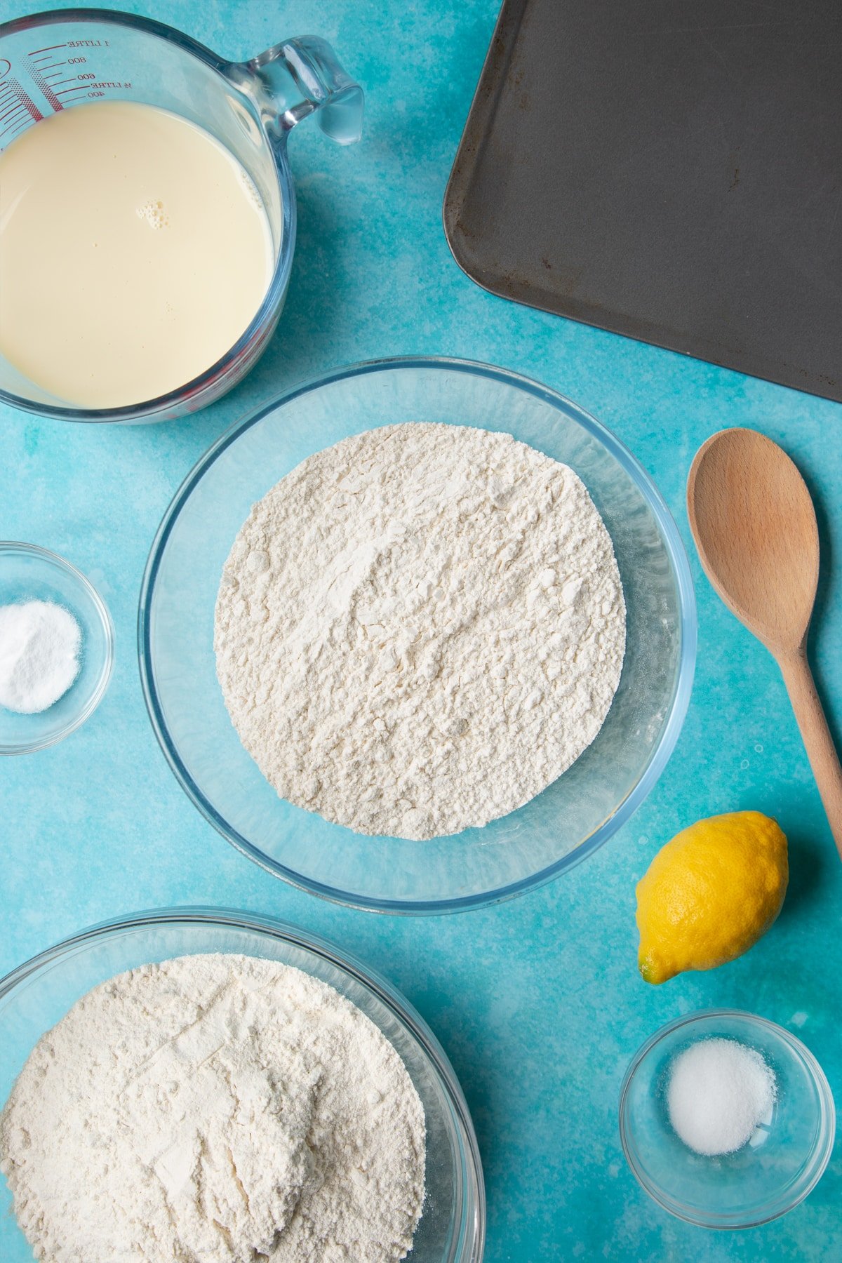 A bowl containing plain flour. Ingredients to make vegan soda bread surround the bowl.