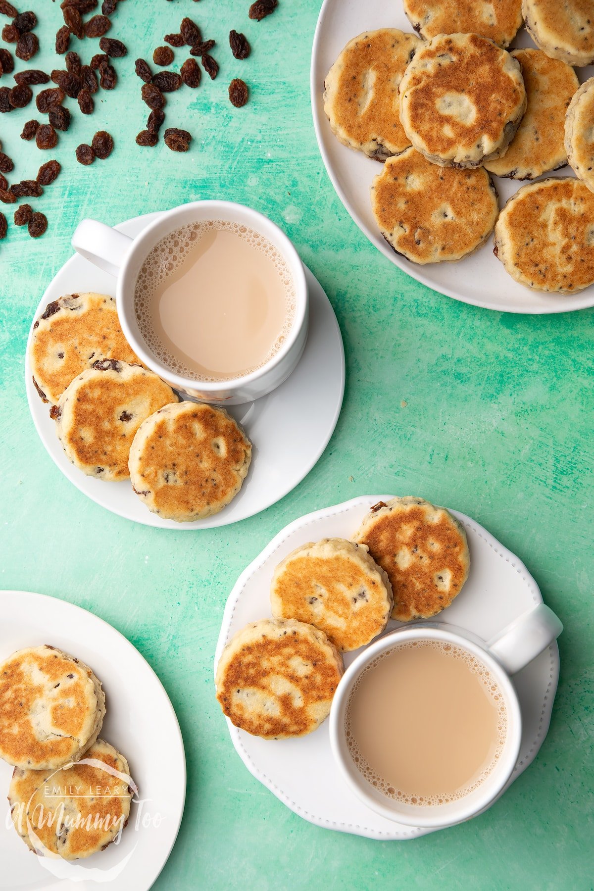Vegan Welsh cakes arranged on a white plate with cups of tea.