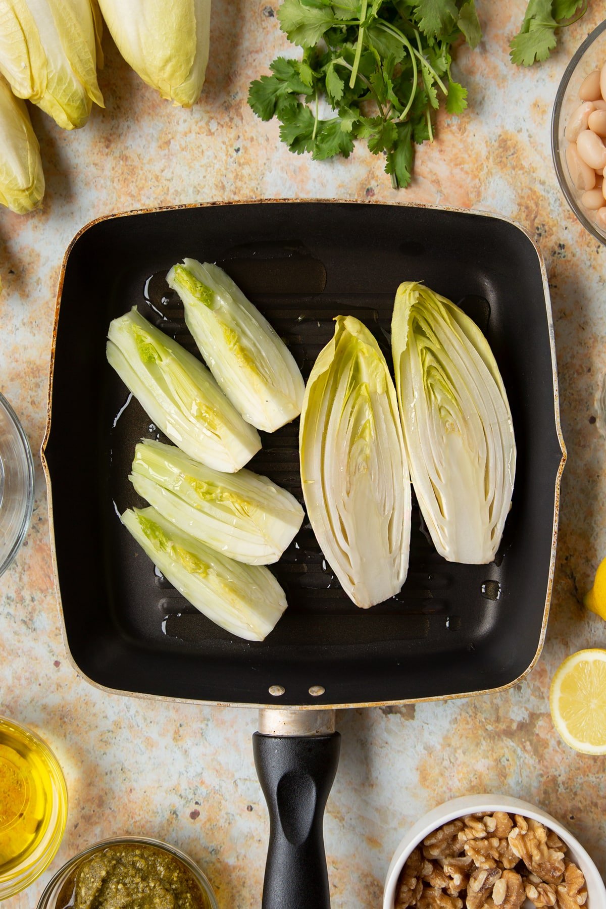 Chicory and fennel pieces in a griddle pan with oil.