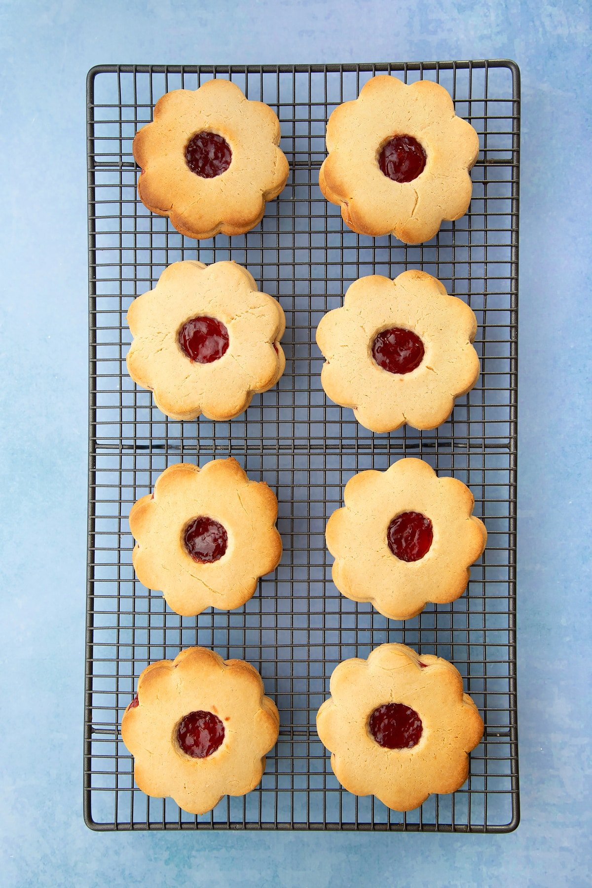 Giant jammie dodgers cooling on a wire rack. 