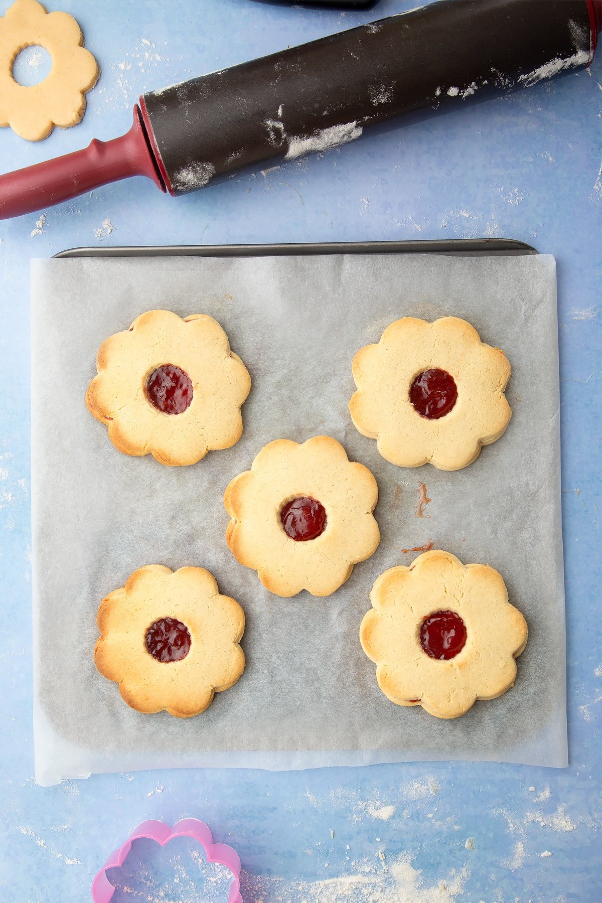 Collage of images showing the making of giant jammie dodgers, including hands breaking open a jammie dodger. Caption reads: giant jammie dodgers quick recipe step-by-step guide