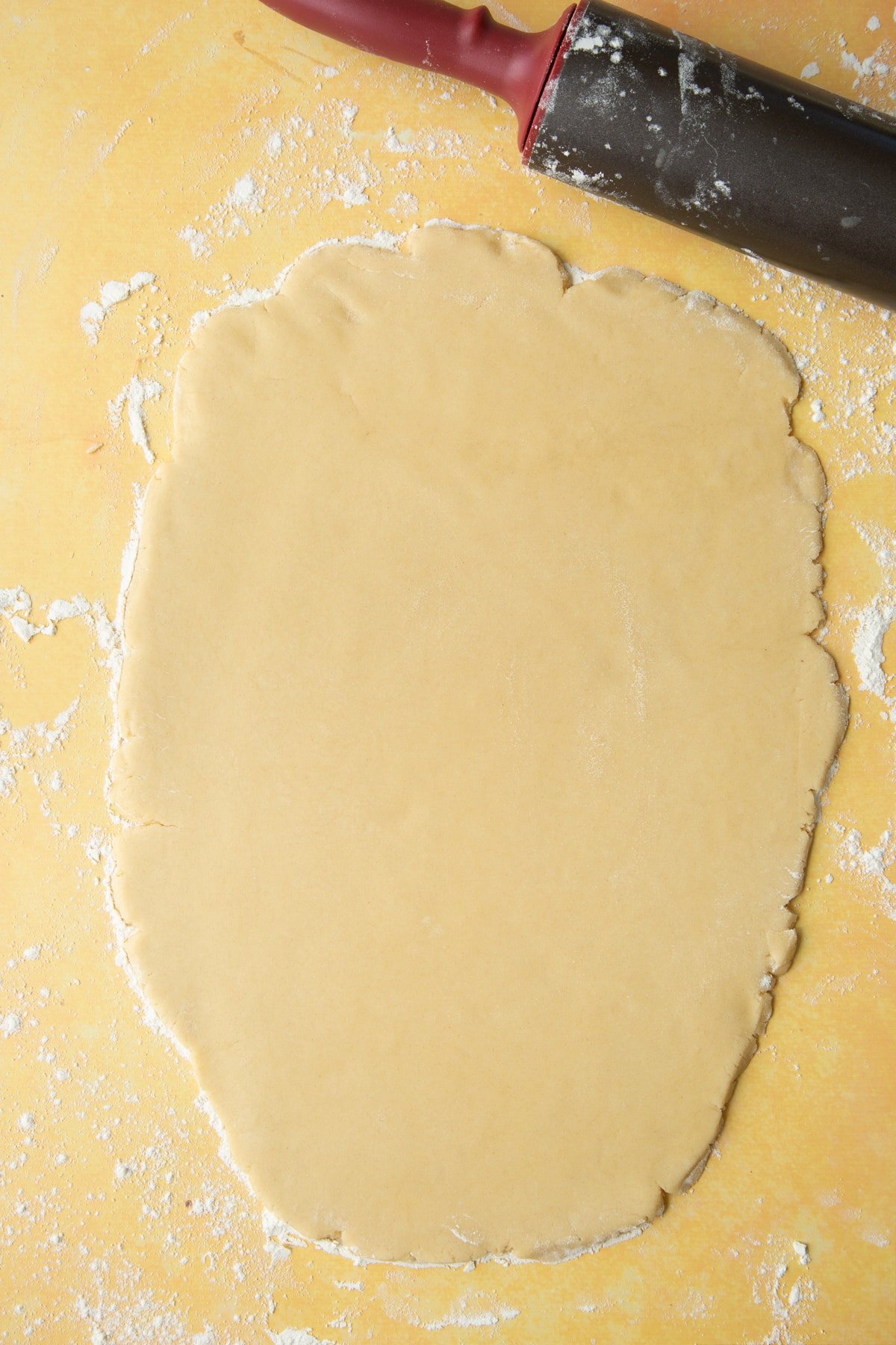 Overhead shot of a the dough being rolled out on the countertop. 
