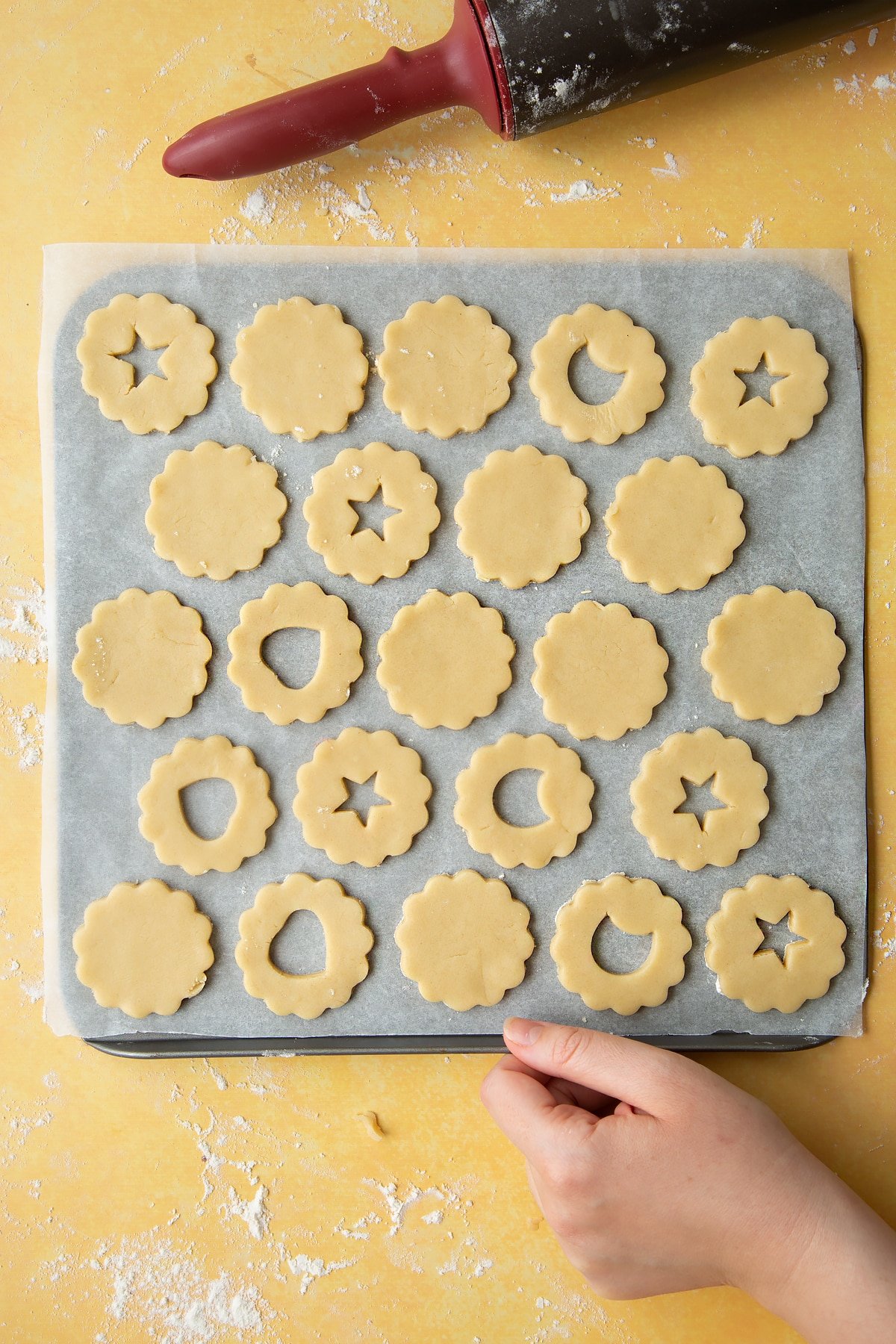 Laying the cut out cookie dough, out on the baking tray. 