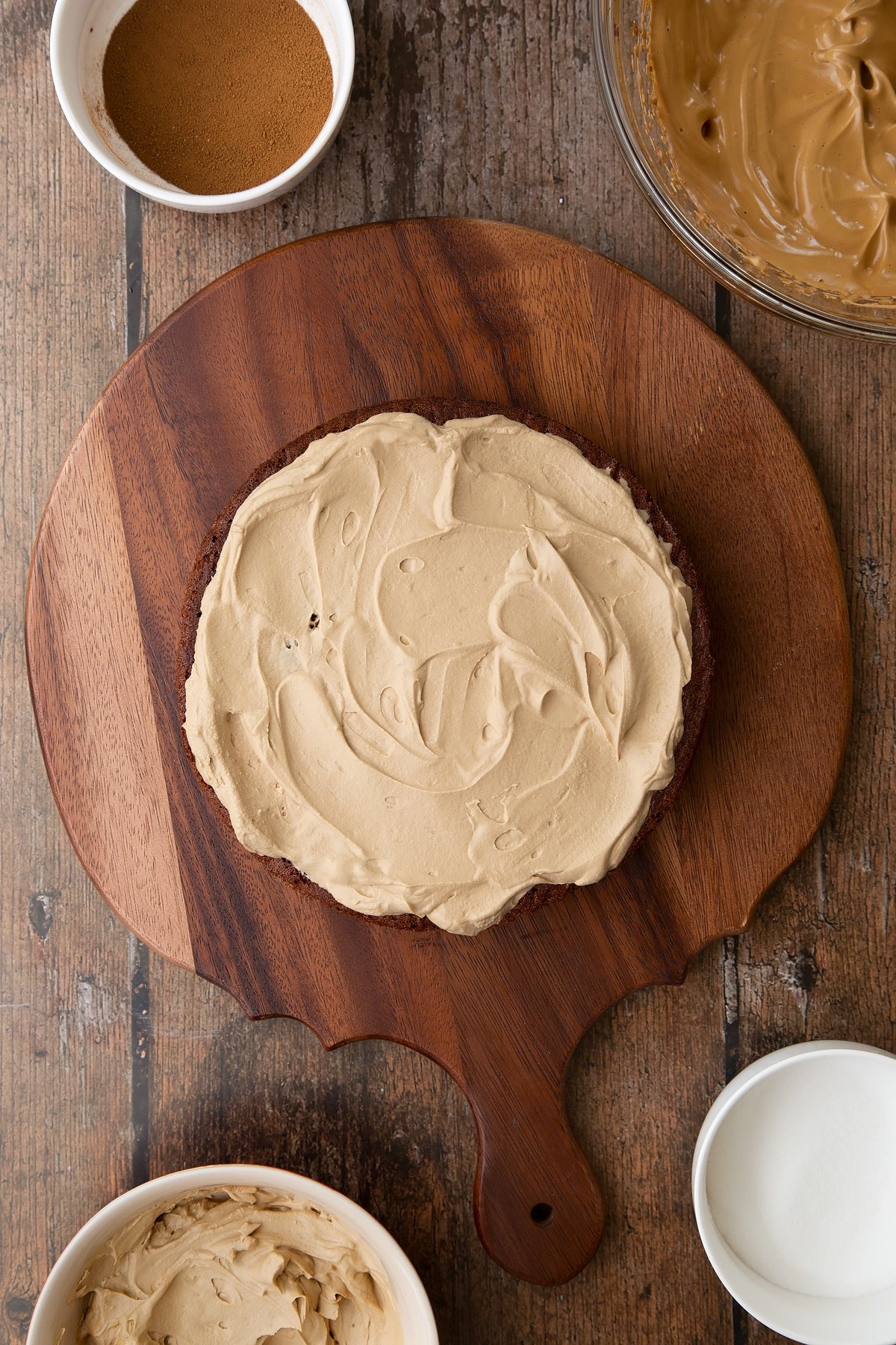 Dalgona coffee cake sponge on a wooden board. Coffee cream is spread on top.