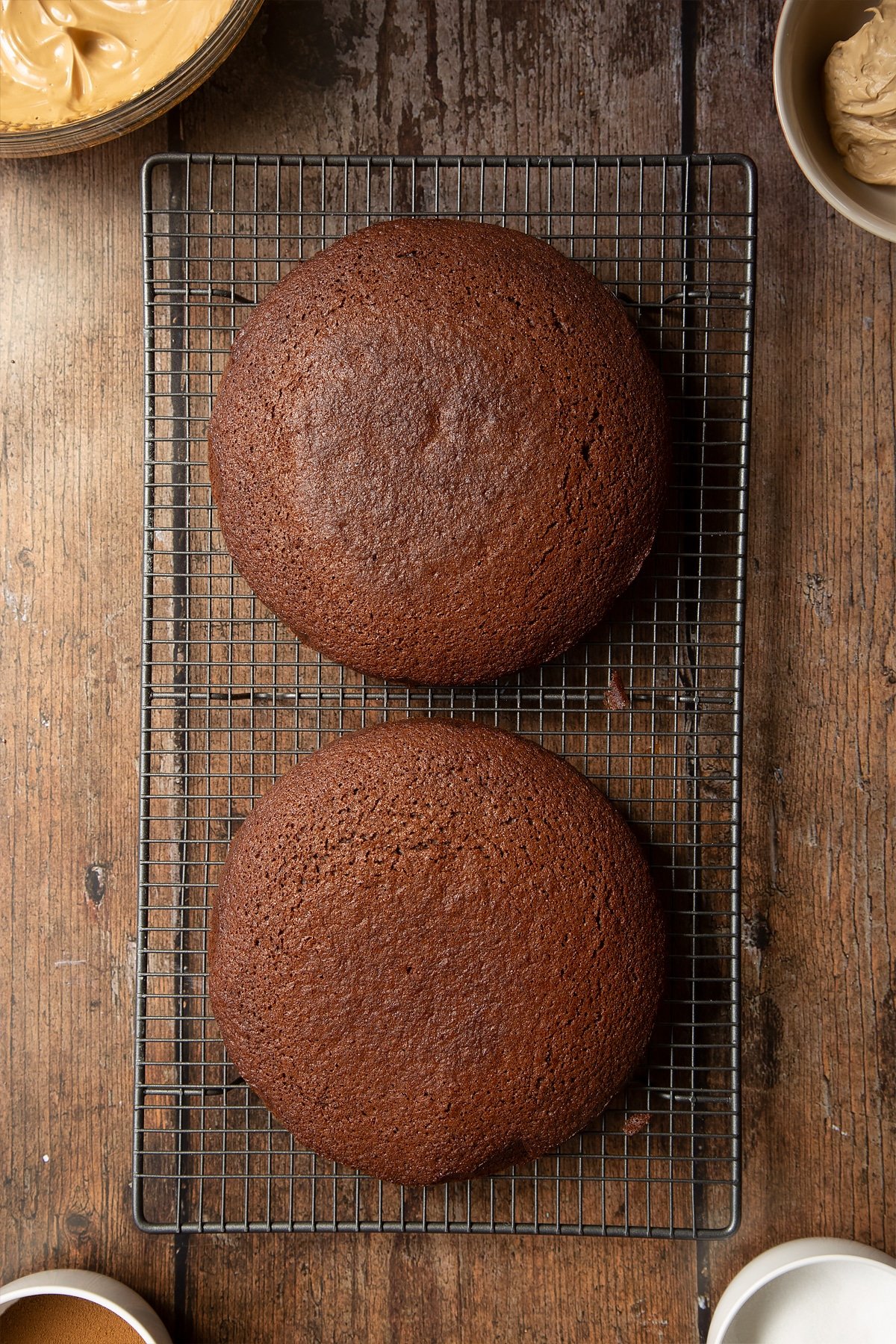 Dalgona coffee cake sponges cooling on a wire rack. 