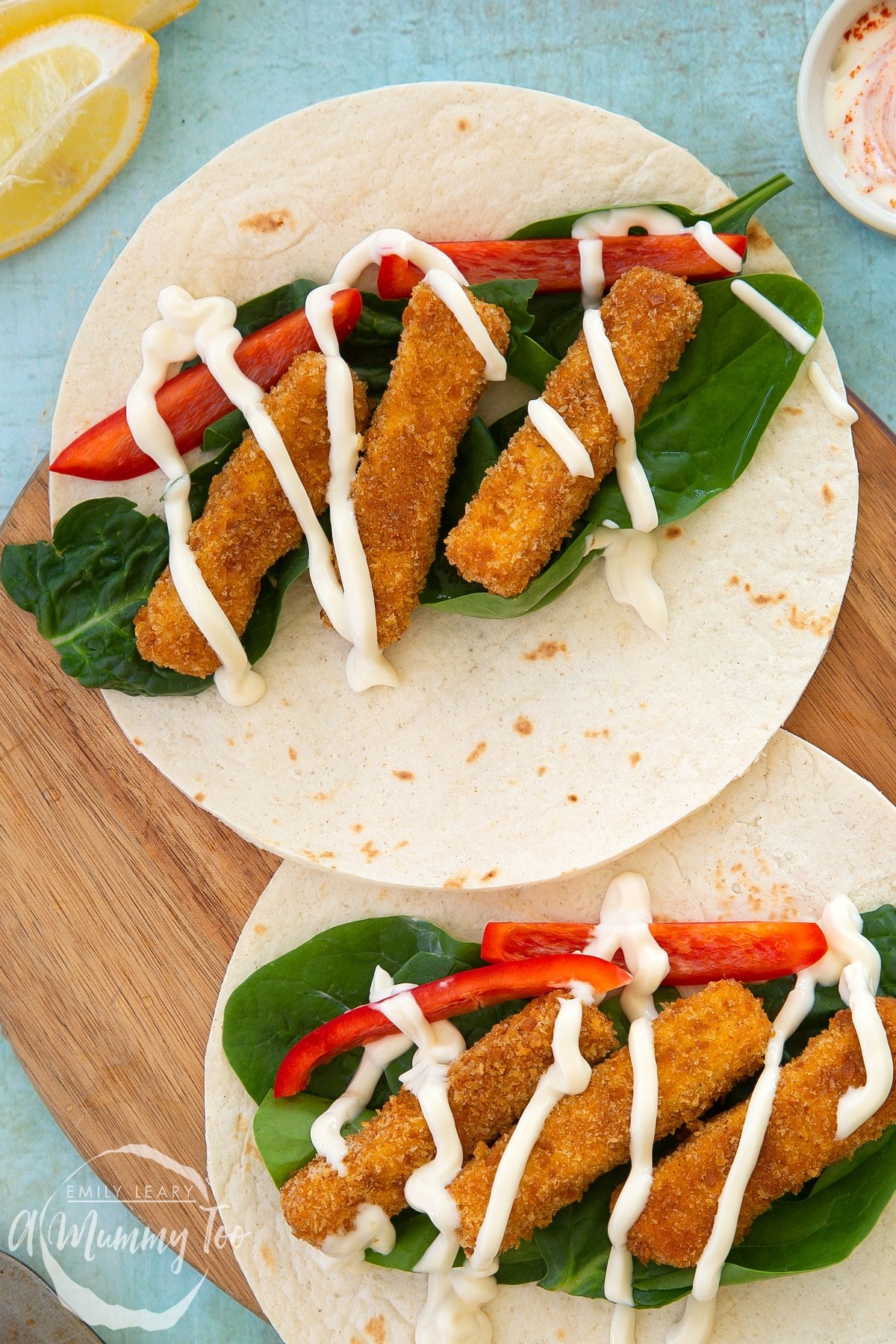 Close up of tofu fish sticks on a two flour tortillas with salad and mayo. 