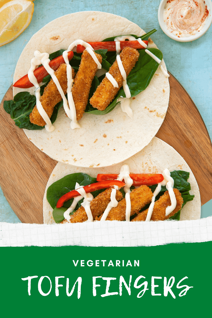 Flour tortillas filled with tofu fish sticks, salad and mayo on a wooden board. Caption reads: vegetarian tofu fish sticks.