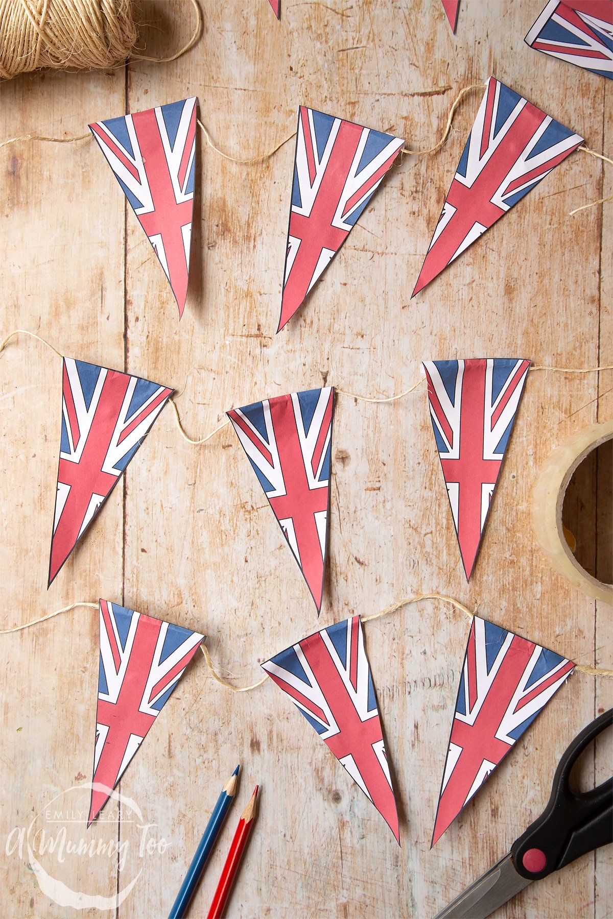 a string of paper bunting with union jack design on a wooden backdrop.