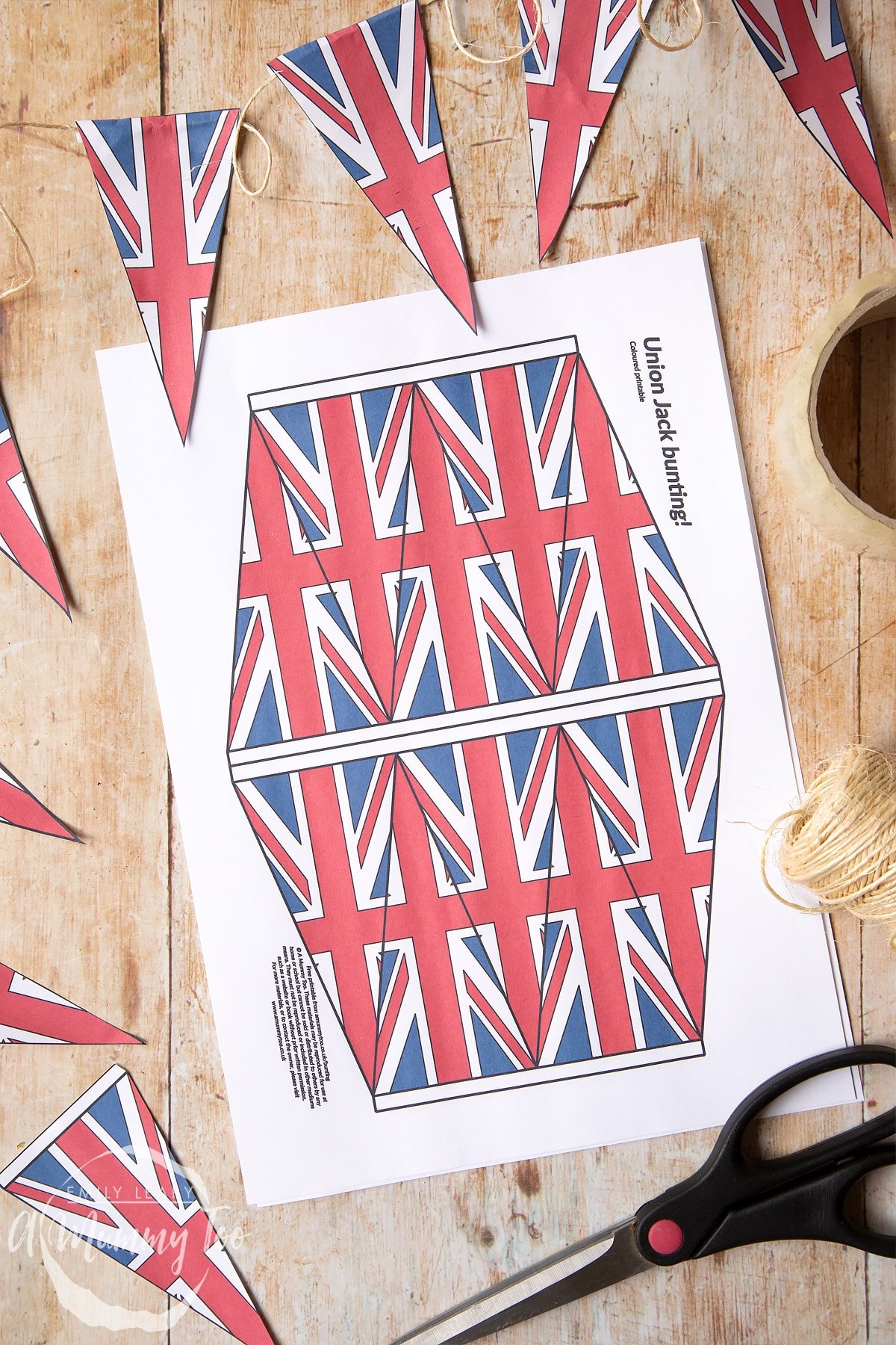 Coloured union jack bunting on string overlapping a printed colour sheet of union jack bunting 