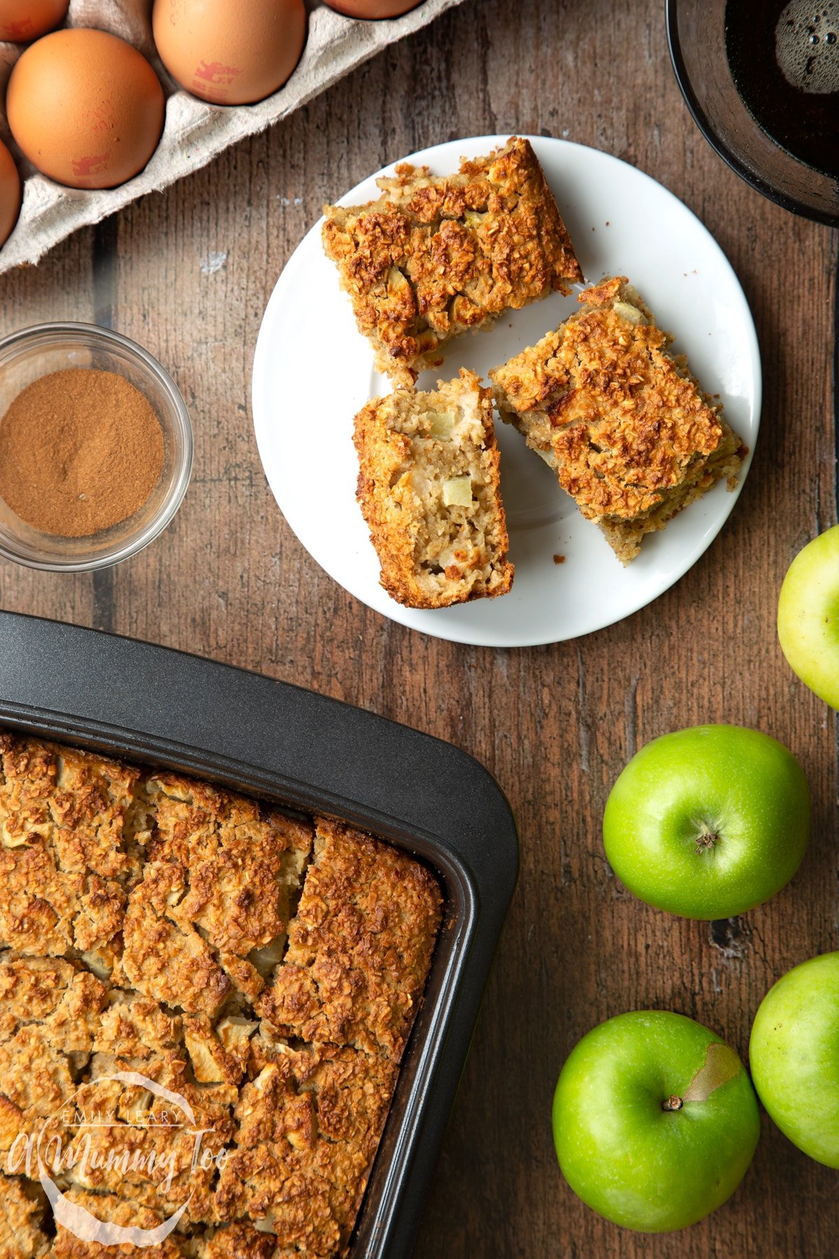 Three porridge squares on a white plate. More of the porridge squares is shown in a baking tray.