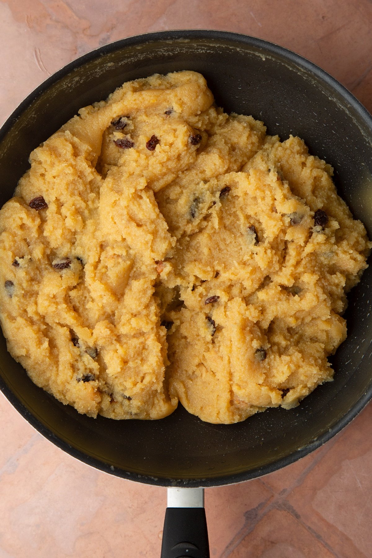 Golden semolina cake batter cooked until thick in a pan.