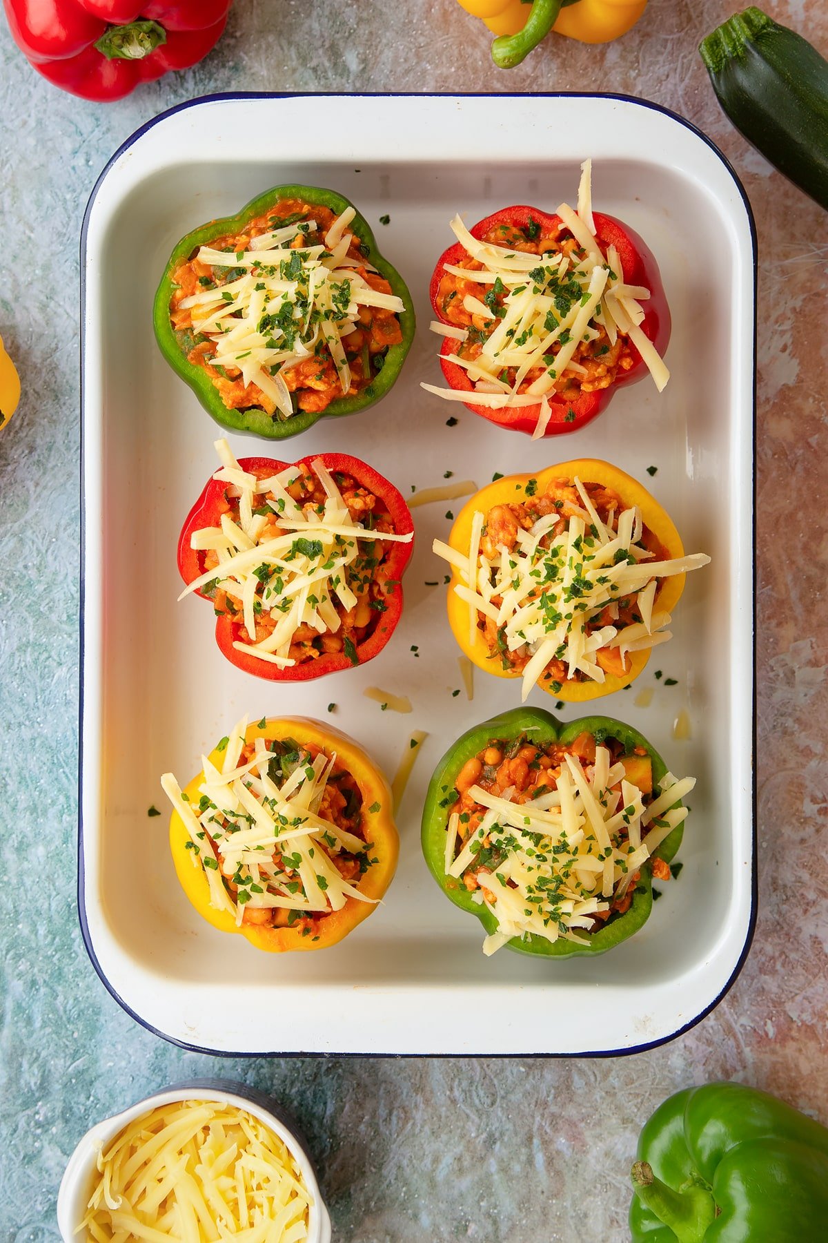 Freshly made baked bean stuffed peppers in a white roasting tray.