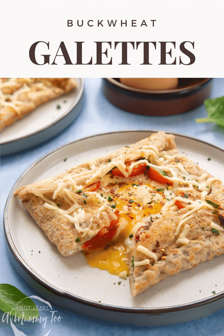 A buckwheat galette on plate with ingredients around it. The galette is filled with spinach, tomatoes, cheese and a lightly cooked egg. The galette has been cut to reveal the custardy yolk. Caption reads: buckwheat galettes