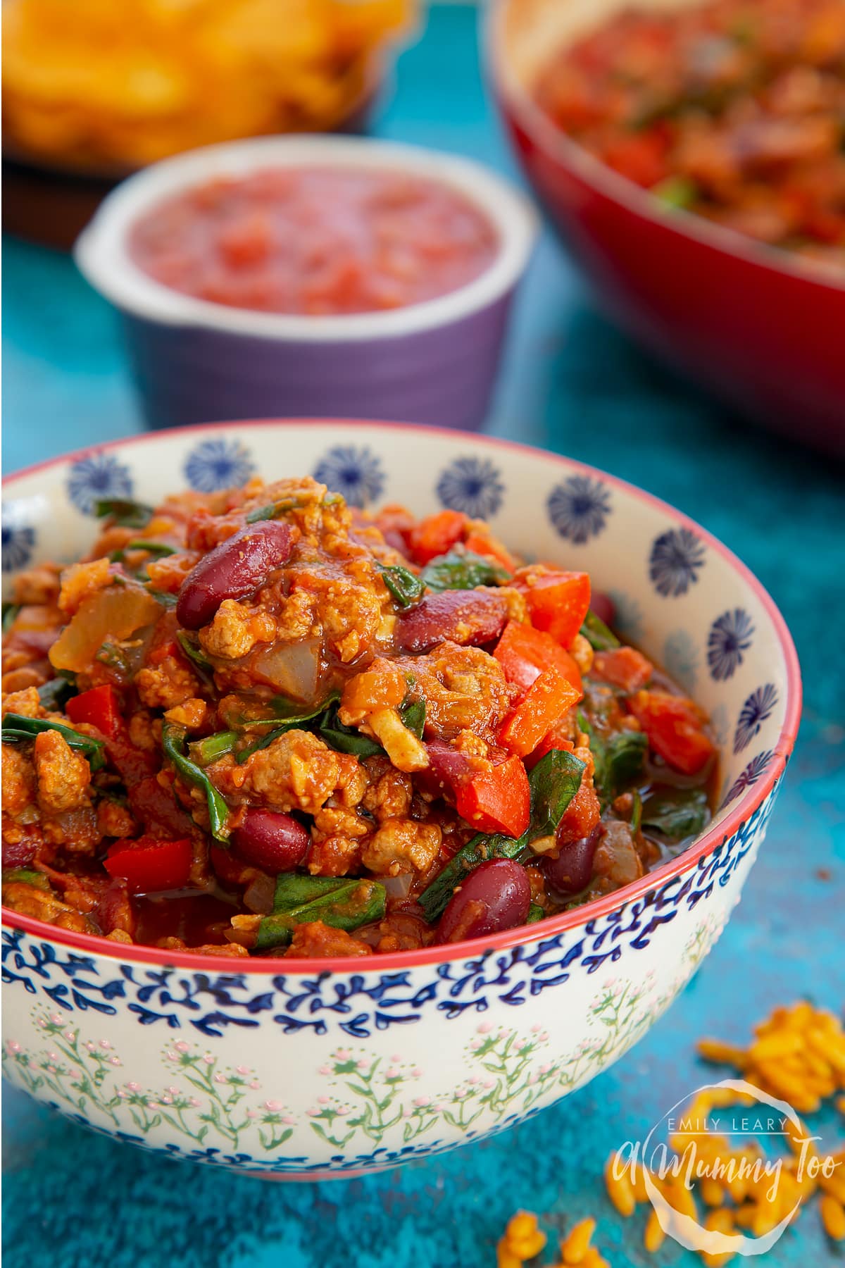 Vegetarian mince chilli in a bowl. More chilli is shown in a pan in the background.