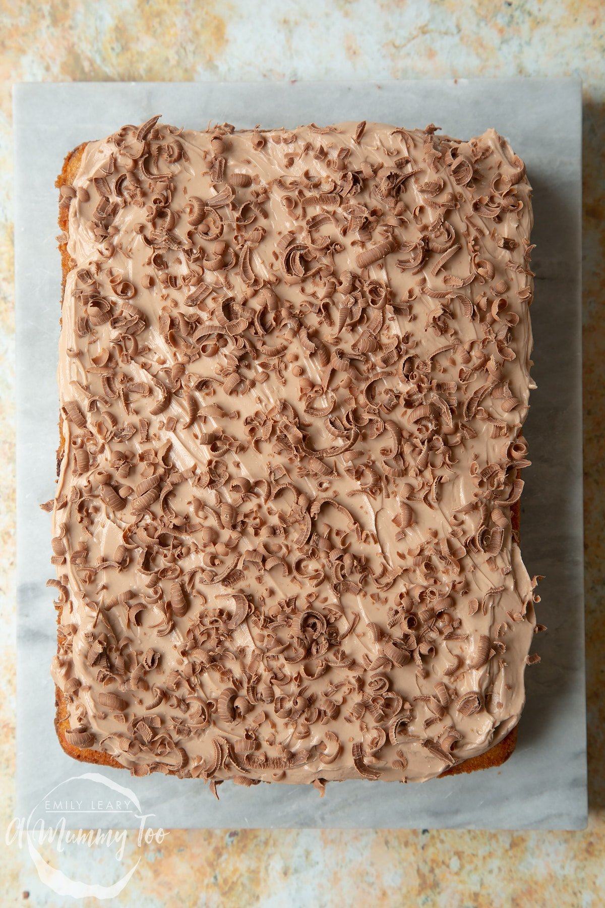 Freshly decorated chocolate chip tray bake on a marble board. 