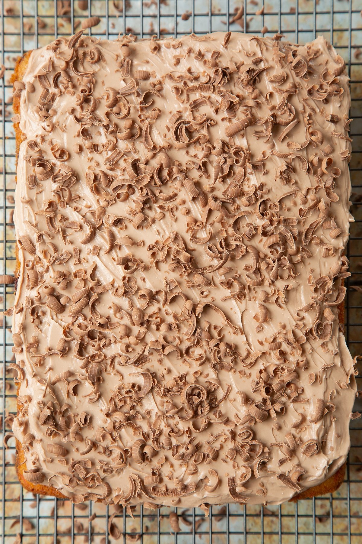 Freshly decorated chocolate chip tray bake on a wire cooking rack. 