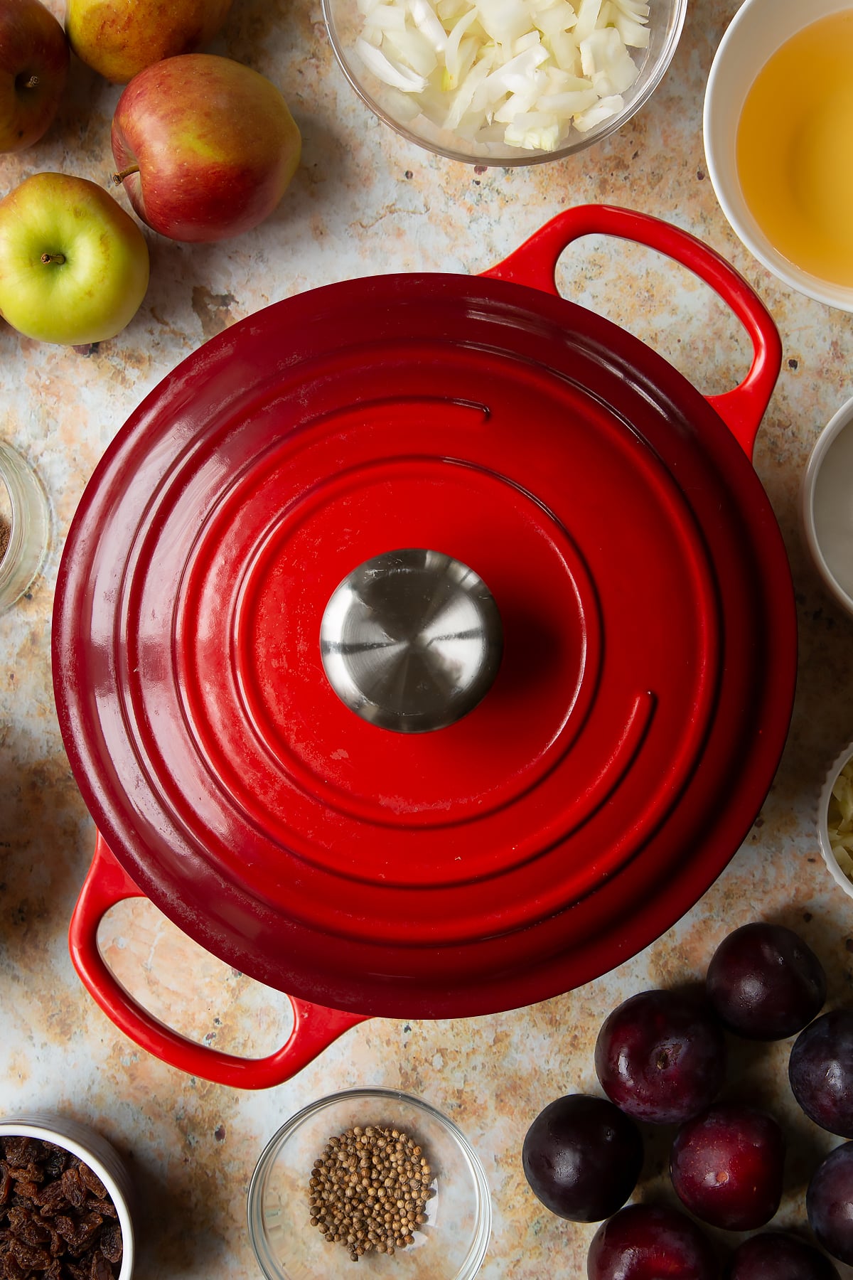 Lidded large pan. Ingredients to make a fruit chutney recipe surround the pan.