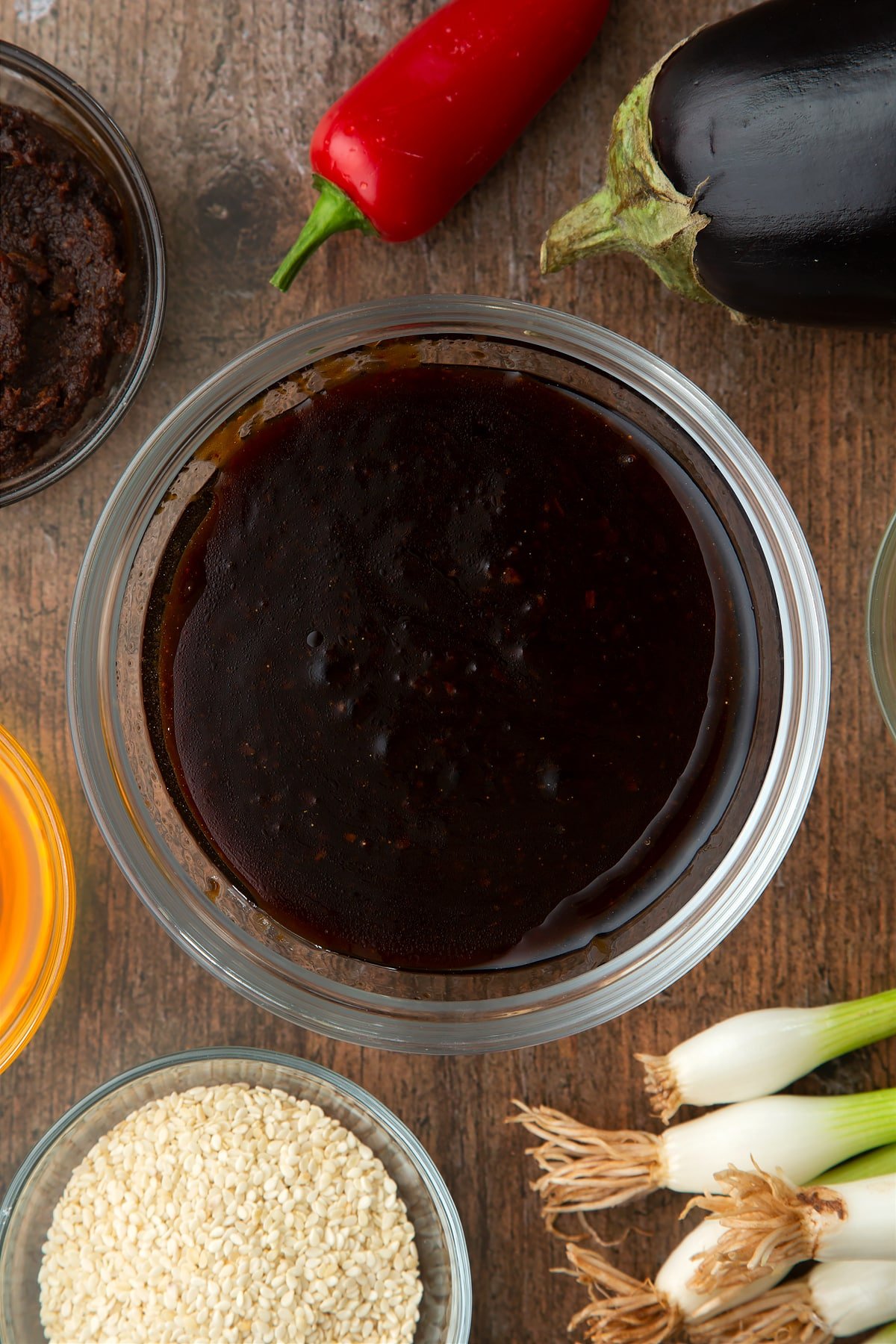 Miso glaze in a bowl. Ingredients to make miso aubergine surround the bowl.