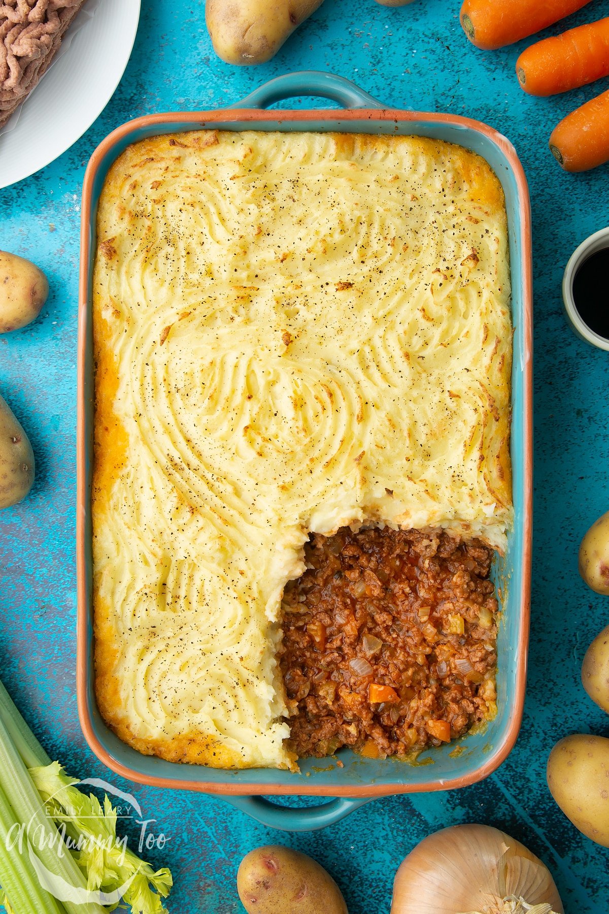 Vegan cottage pie in a roasting dish. Some of the pie has been served.
