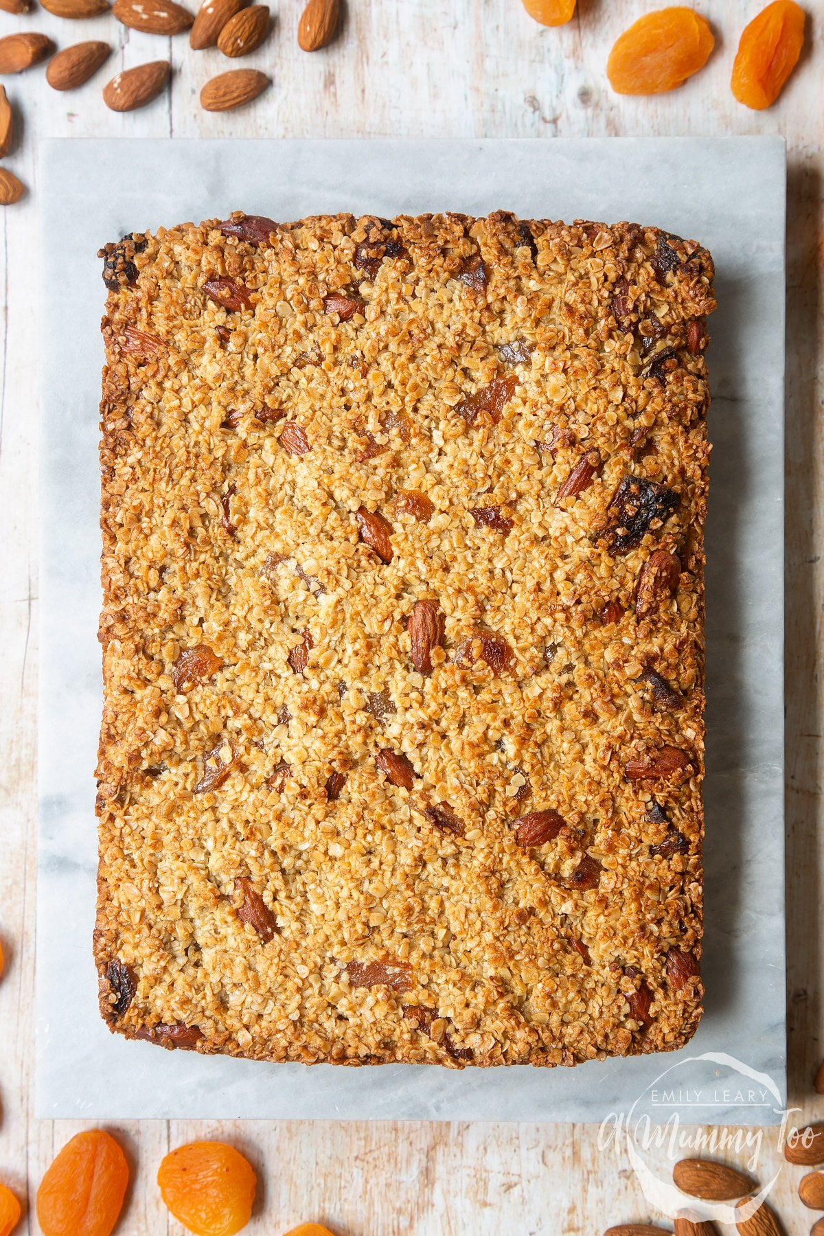 Overhead shot of baked Apricot oat served on a marble slab with a mummy too logo in the lower-right corner