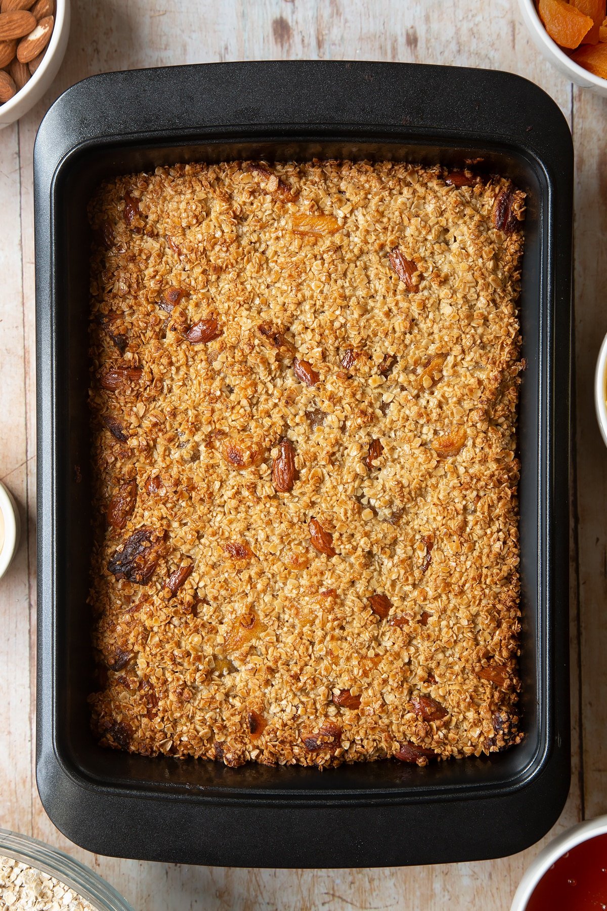 Overhead shot of baked Apricot oat in a black baking tin