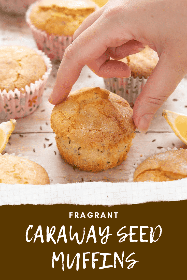 overhead shot of a hand holding uncased lemon caraway seeds muffin with graphic text FRAGRANT CARAWAY SEED MUFFIN below