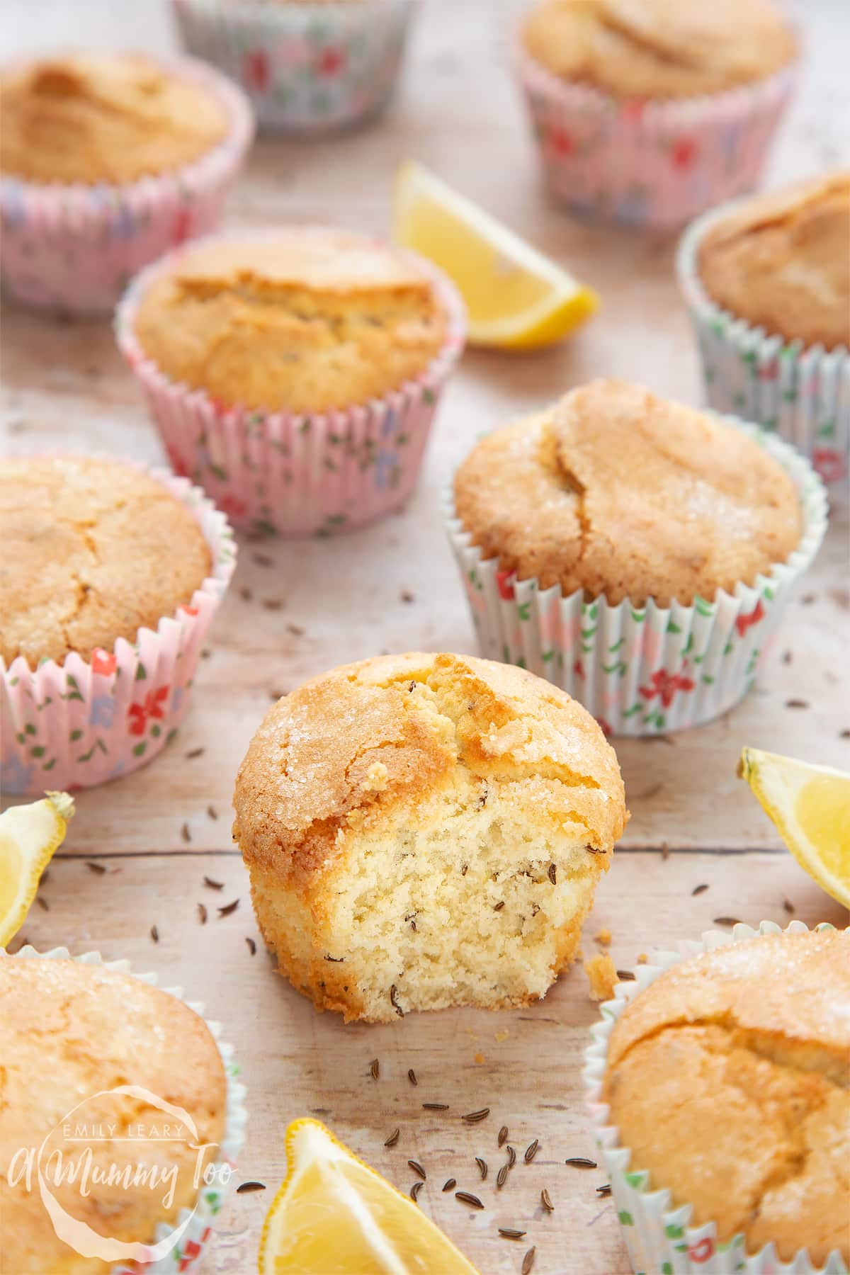 Front angle shot of Caraway seed muffin and lemons with a mummy too logo in the lower-left corner