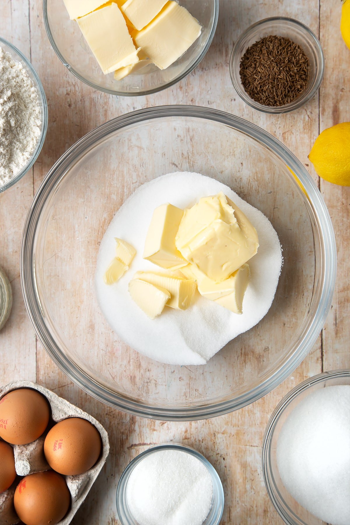 Overhead shot of butter and sugar in a clear bowl