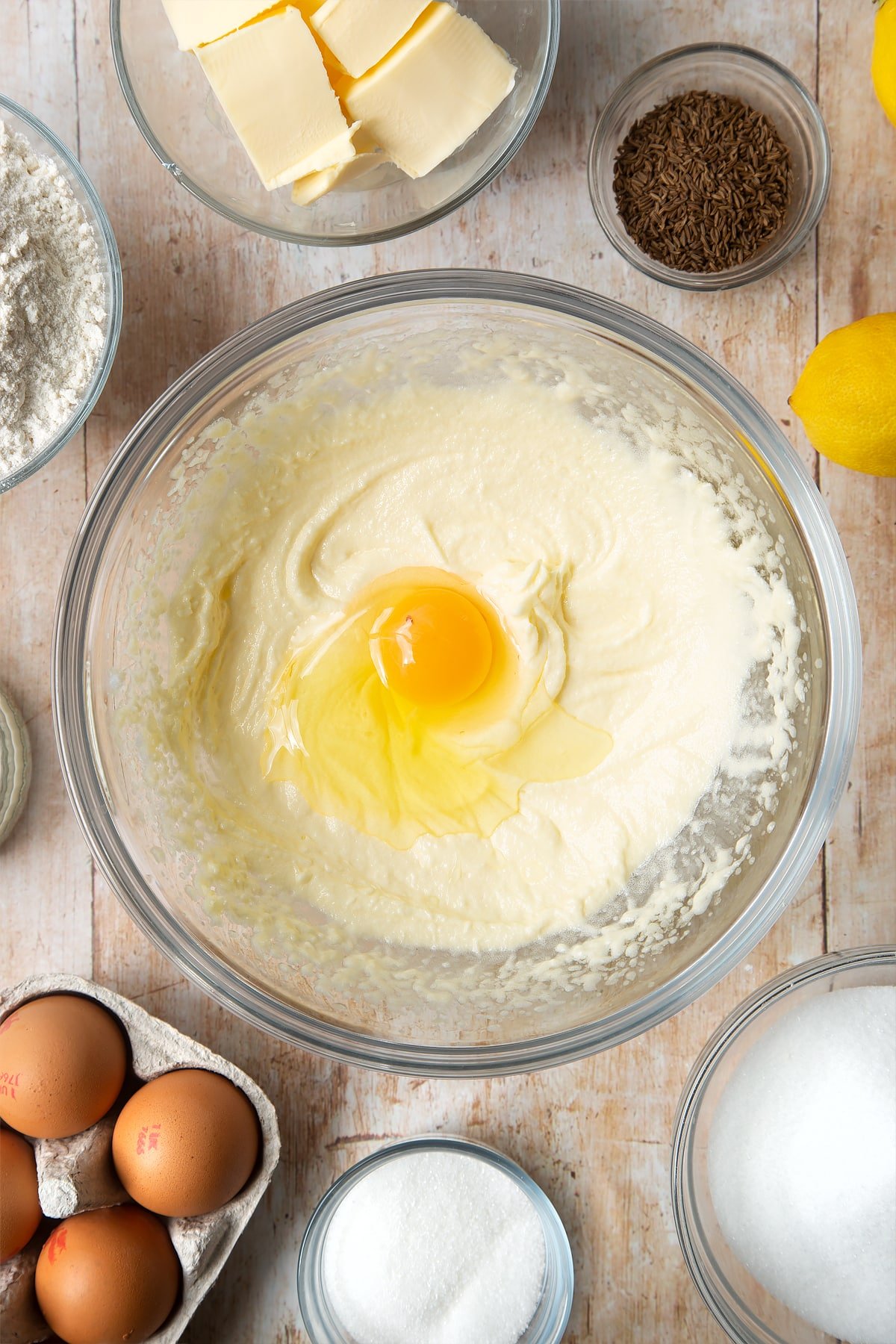 Overhead shot of butter mix and an egg in a clear bowl