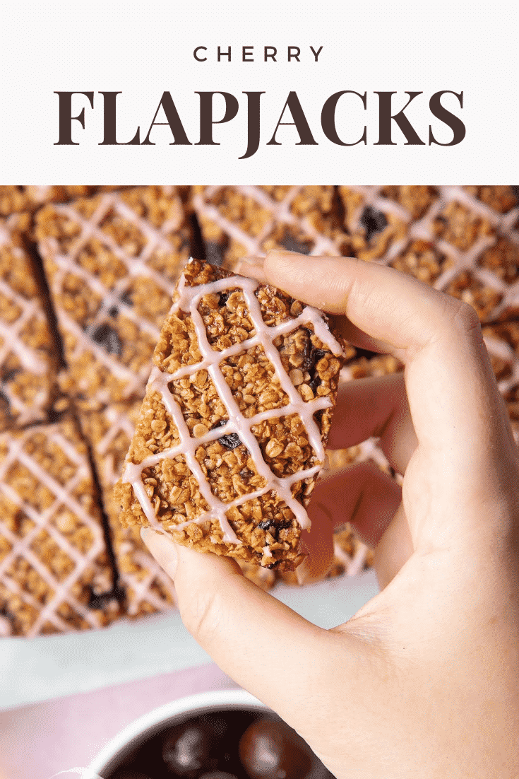 Graphic text step-by-step recipe CHERRY FLAPJACKS above overhead shot of a hand touching a cherry oat bar with website URL below