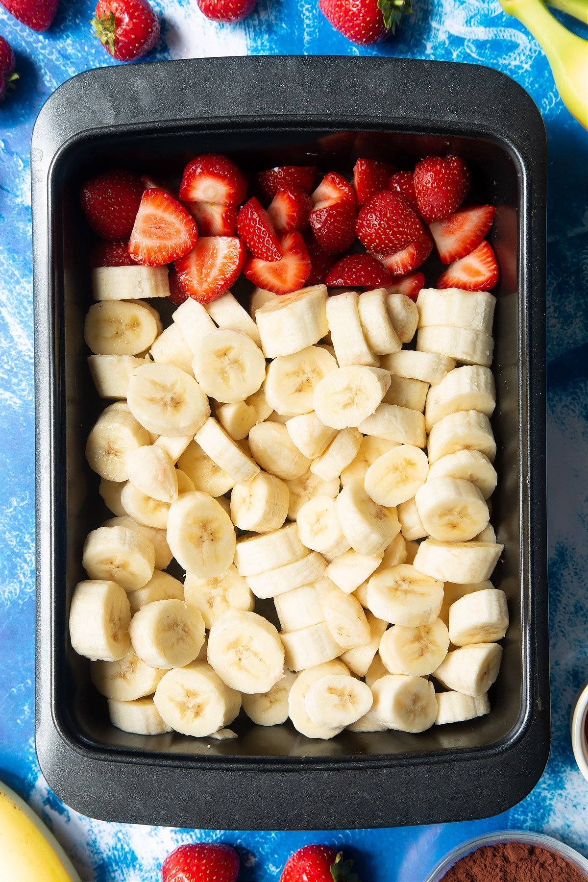 Sliced bananas and strawberries in a tray. 