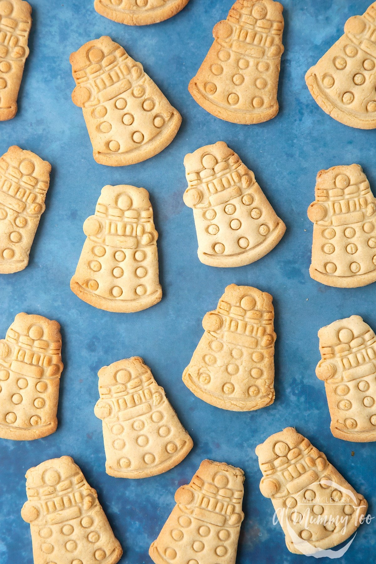 Dalek cookies on a blue background. The cookies are undecorated.