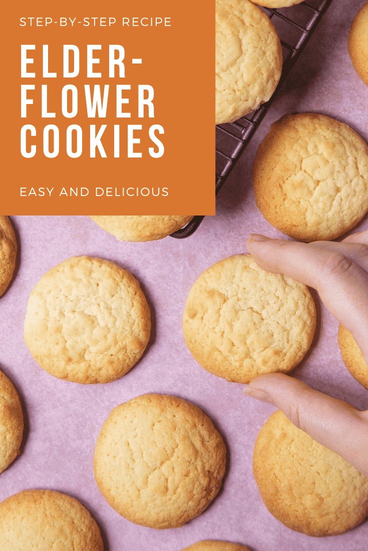 Overhead shot of the elderflower cookies. Some are cooling on a wire rack, others are on a pink counter top. In the top left hand corner there's some text describing the photo for Pinterest.