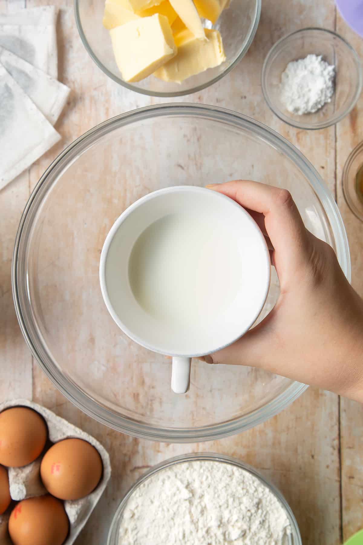 Overhead shot of a hand holding milk in a mug