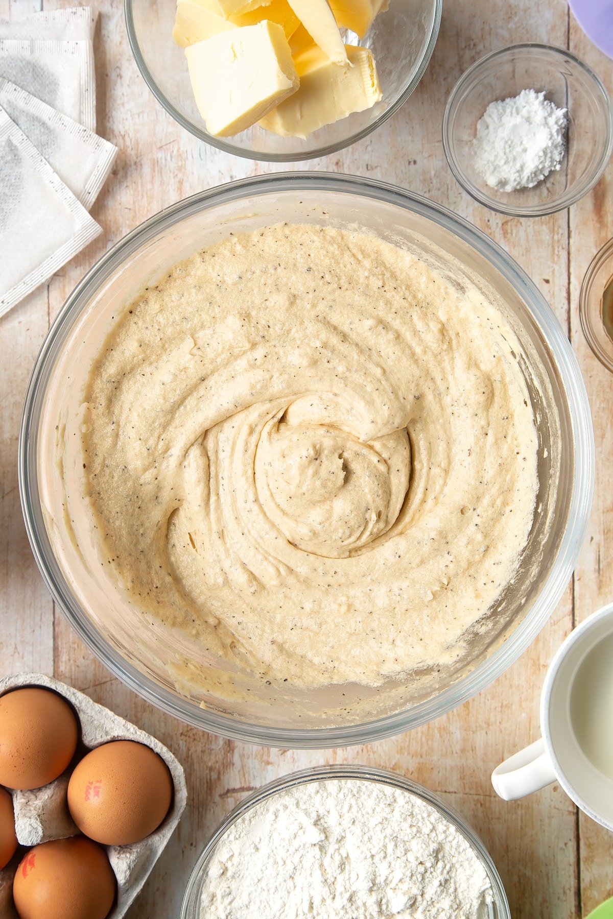 Mixing in the cake mixture in a clear bowl.