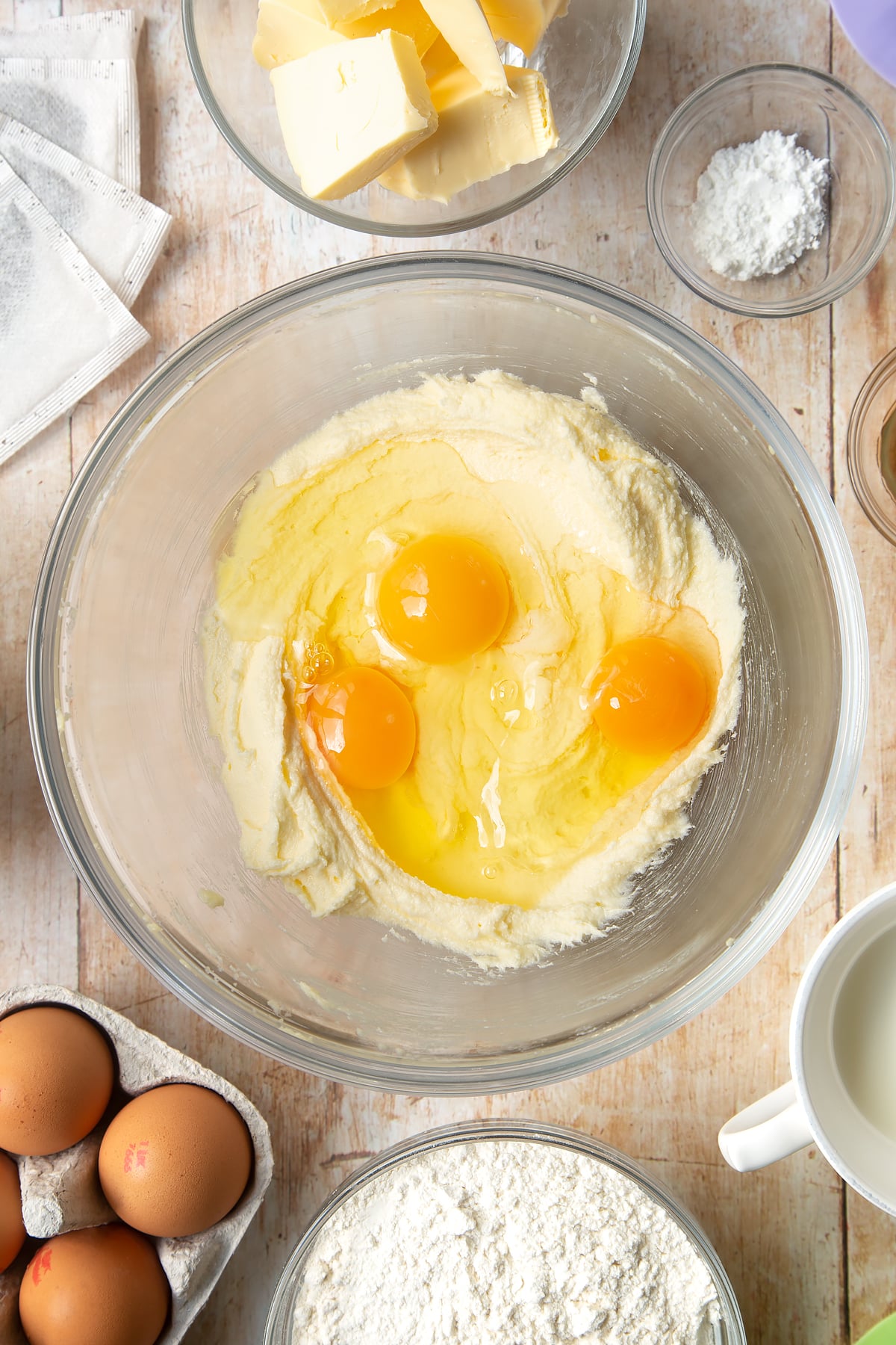 Overhead shot of eggs and mixed butter in a large bowl