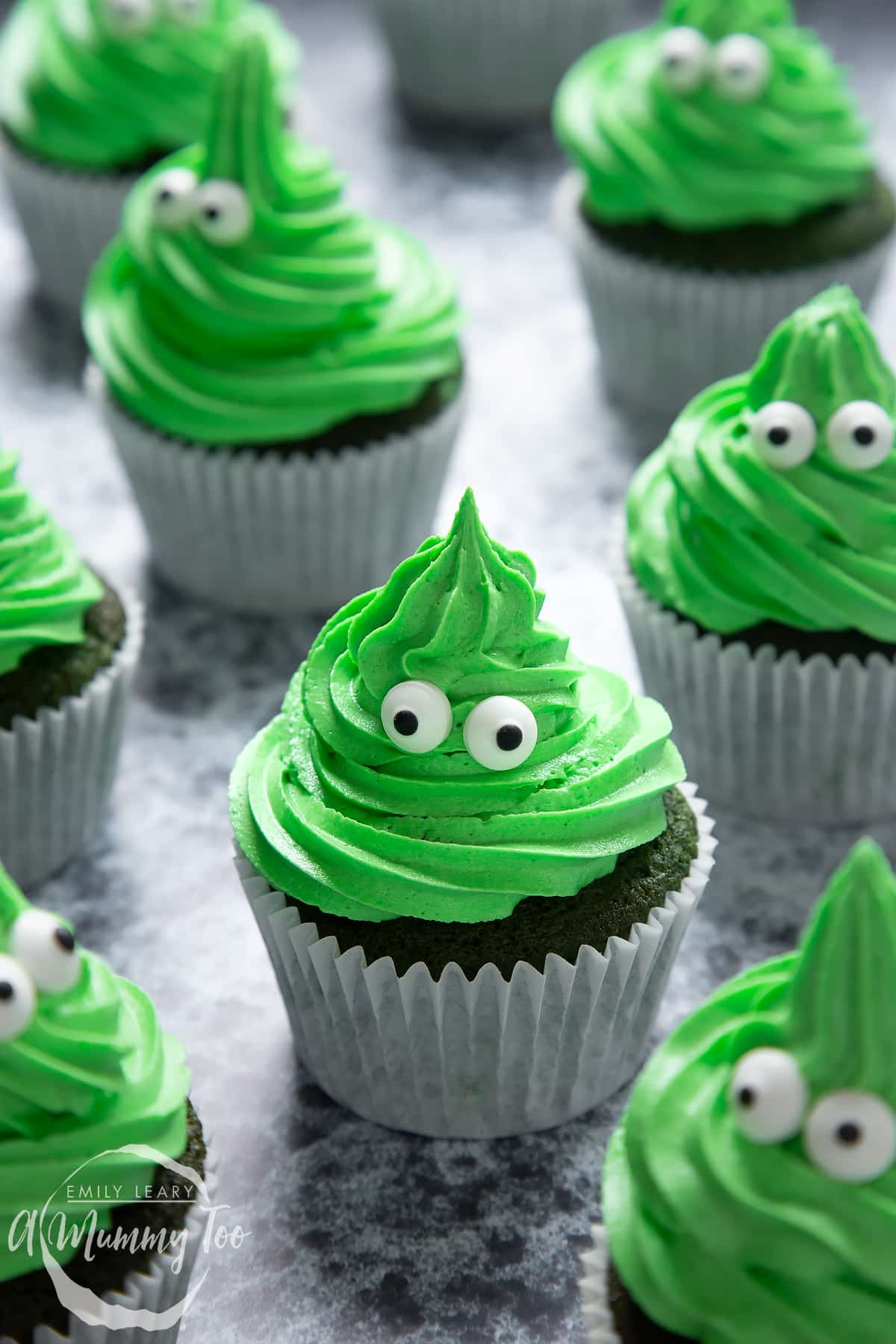 Green monster cakes made with dyed-green chocolate chip cupcakes topped with green peppermint frosting with added candy eyes.