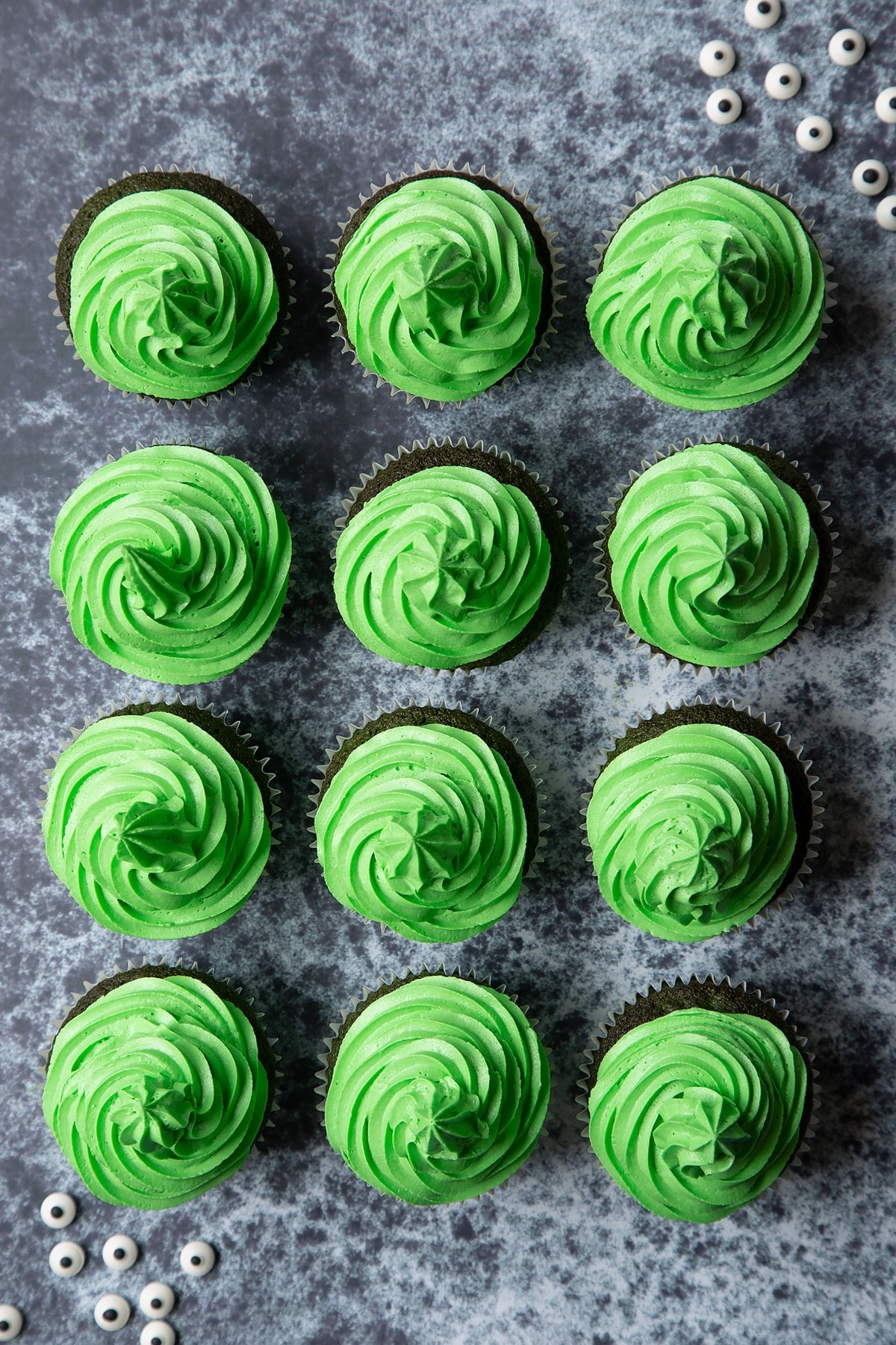 Green vanilla chocolate chip cupcakes decorated with swirls of green peppermint frosting.