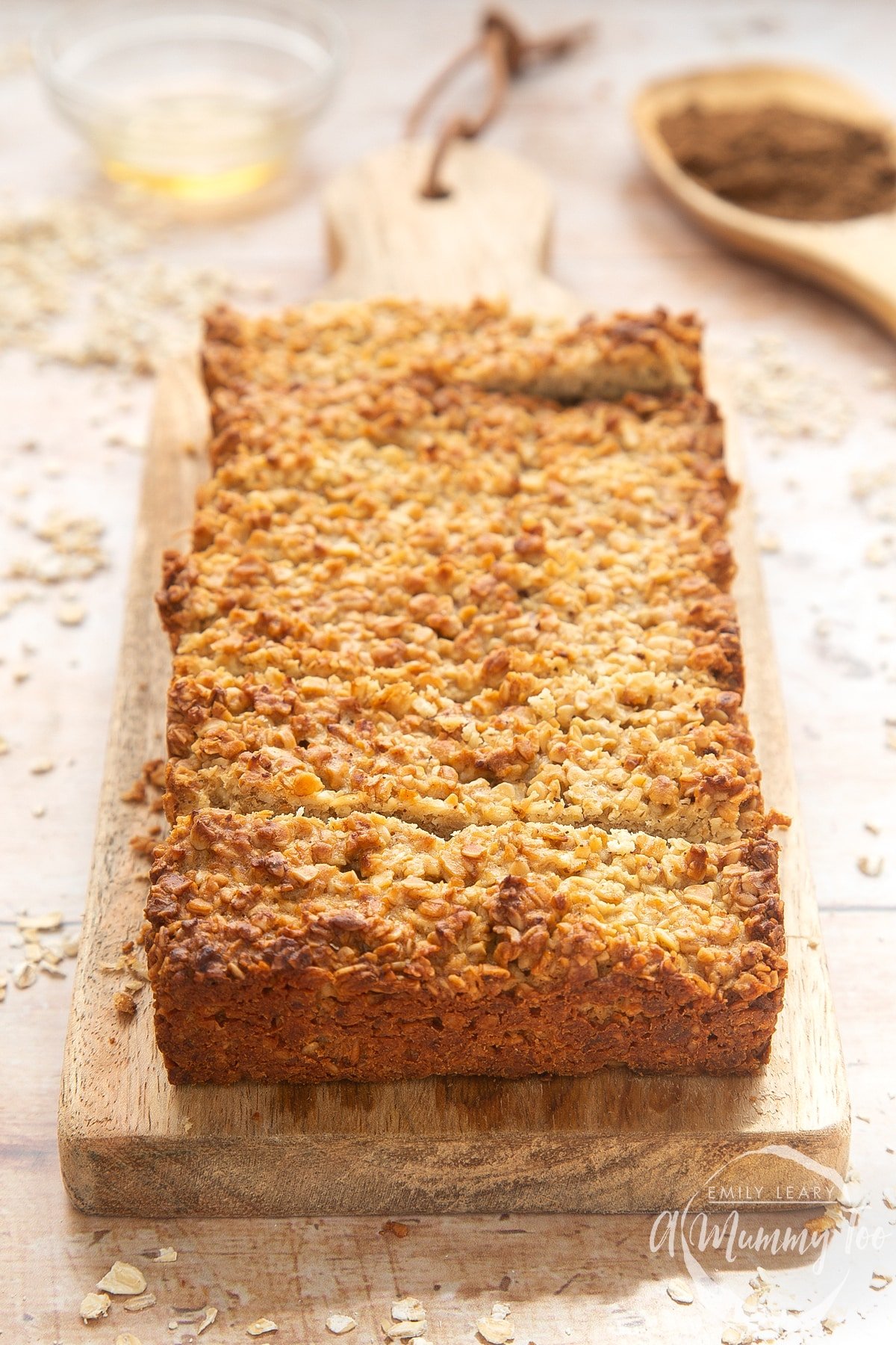 Front angle shot of vanilla oat bars flapjacks served on a wooden platewith a mummy too logo in the lower-right corner