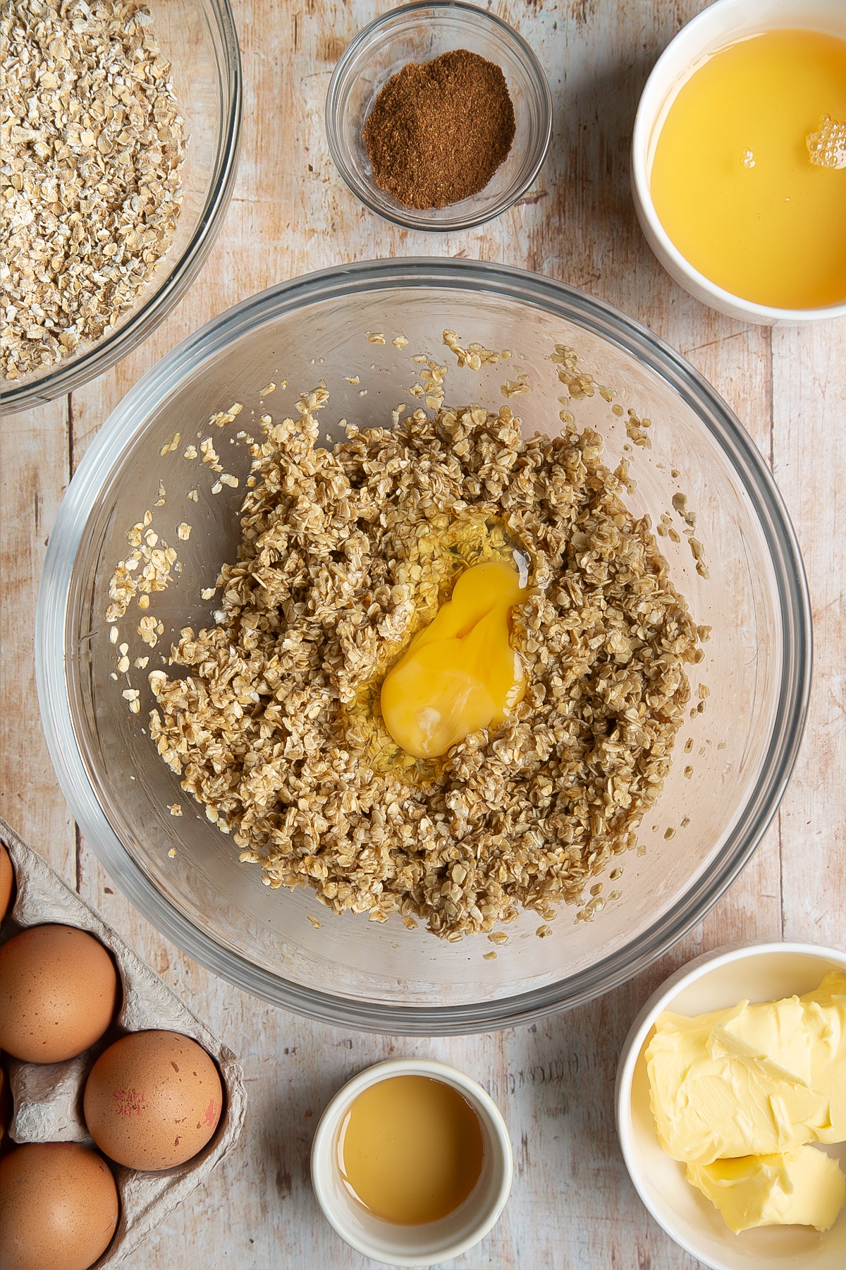 Overhead shot of oats mix with one egg in a large clear bowl