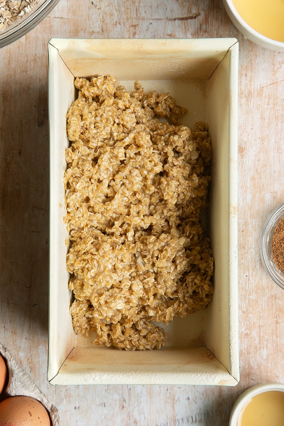 Overhead shot of oats mix in a greased loaf tin