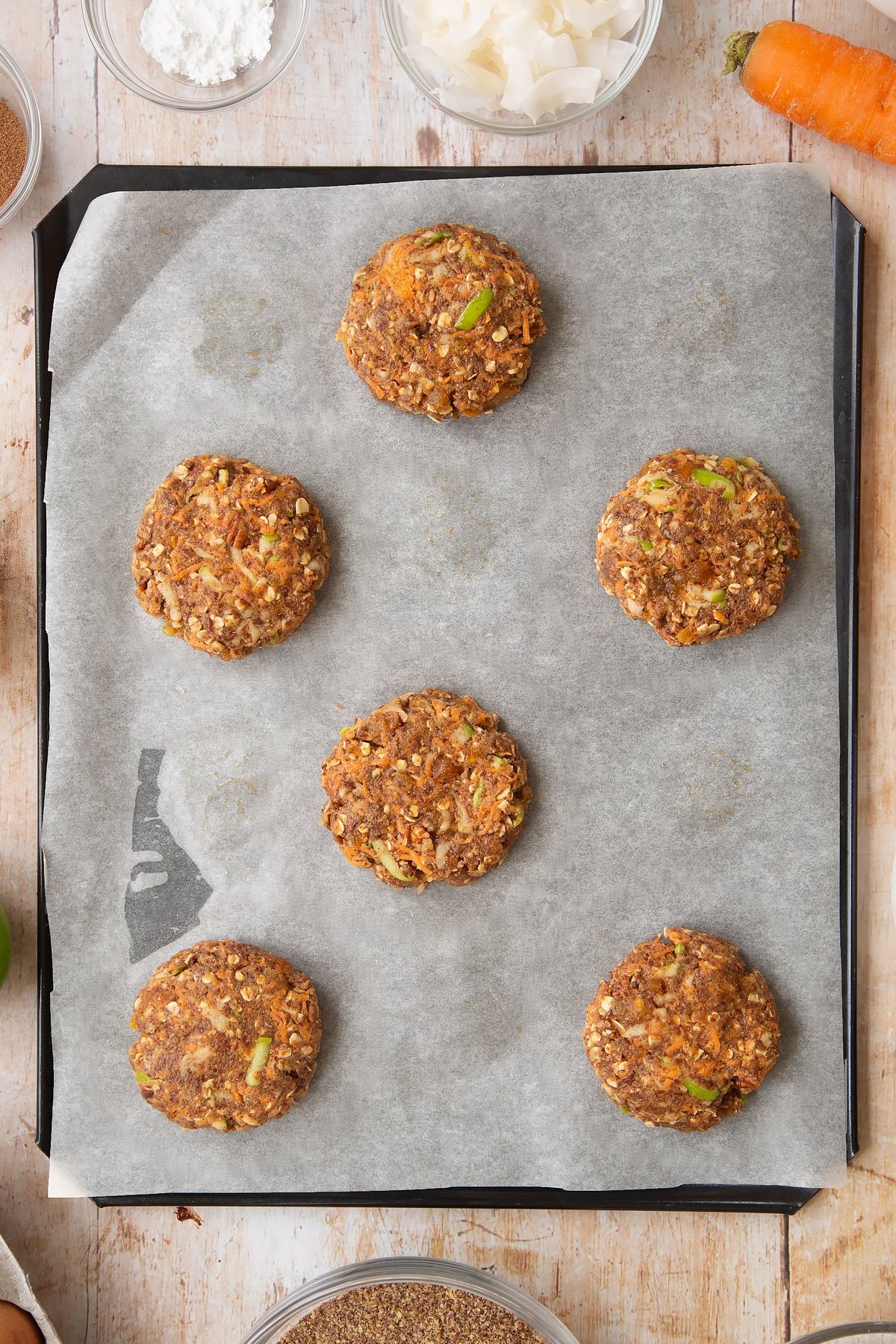 Front angle shot of a hand holding Superfood breakfast cookies served on a wooden board with a mummy too logo in the lower-right corner