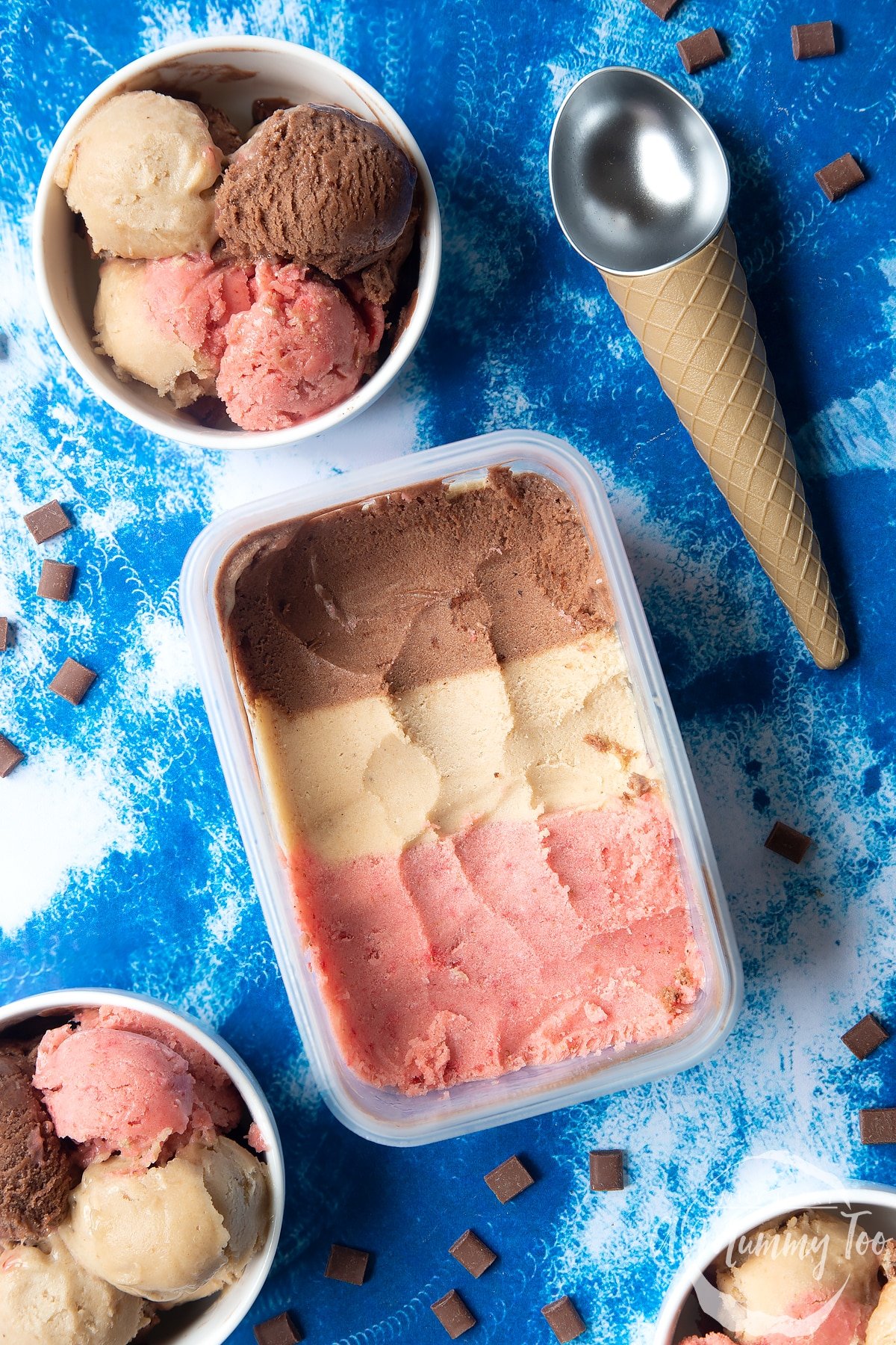 Dairy-free Neapolitan ice cream served to three small white bowls. Ice cream is also shown in a tub.