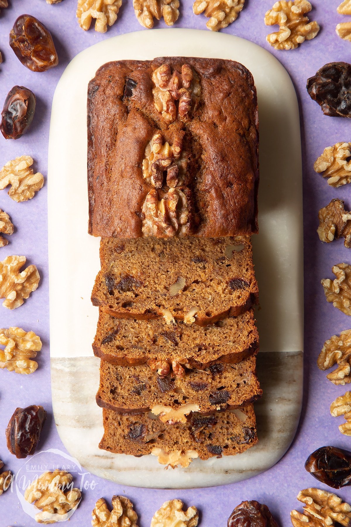 Overhead shot of teabread mix topped with walnut halves in a white loaf tin