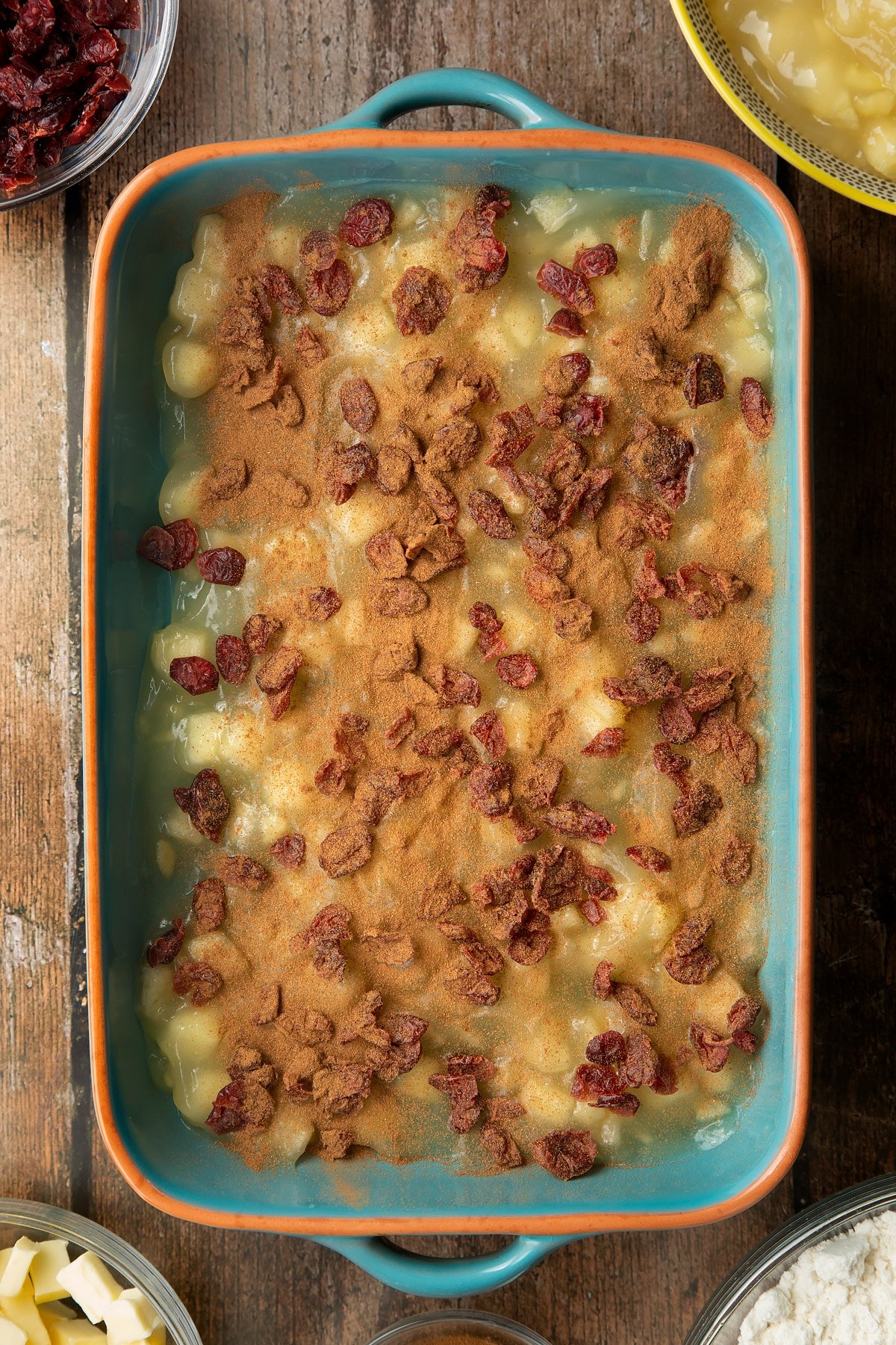 Tinned apple filling, dried cranberries and cinnamon in a roasting tray.