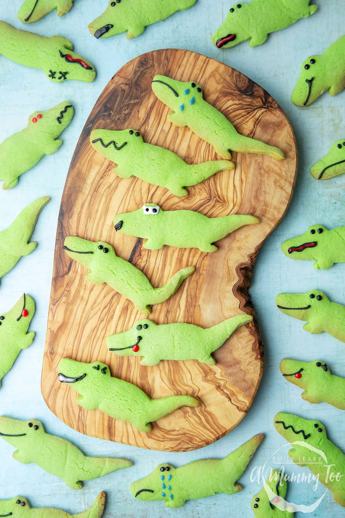 Overhead shot of green Crocodile cookies served on a wooden plate with a mummy too logo in the lower-right corner